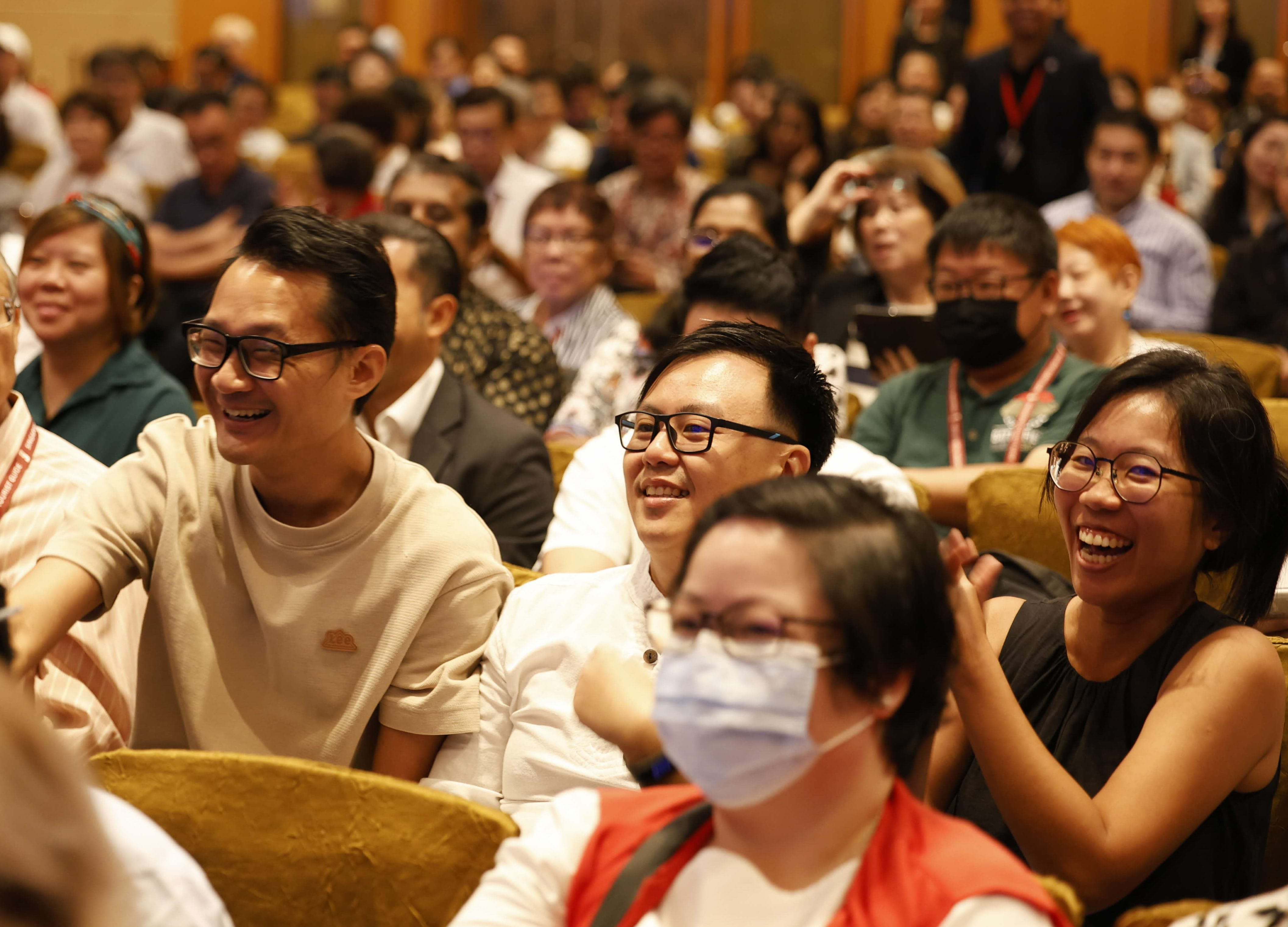 Attendees smiling and participating in e-quiz to win limited-edition Merlion LABUBU plush pendants.