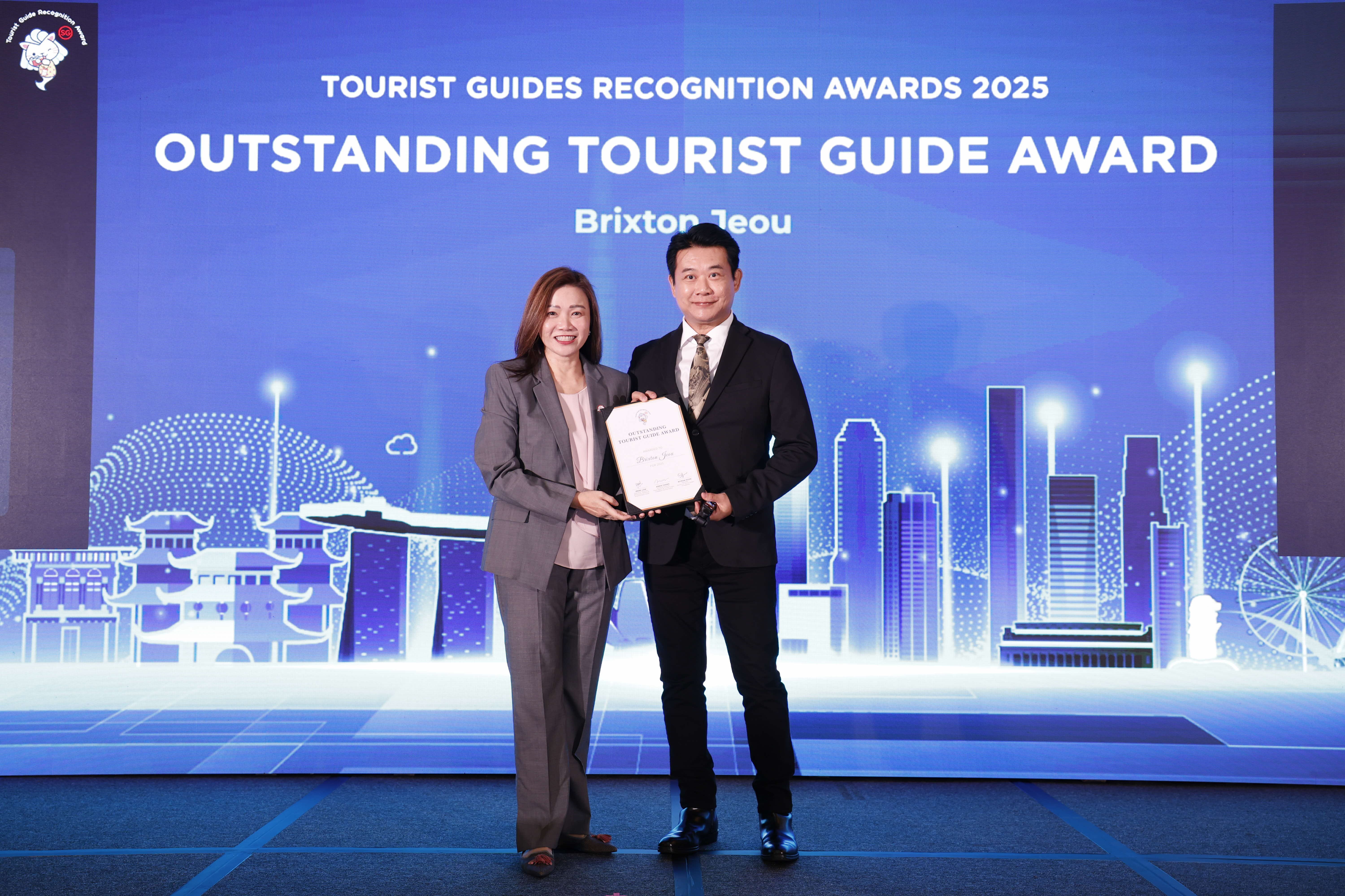Brixton Jeou being presented the Outstanding Tourist Guide Award by STB Chief Executive Ms Melissa Ow.