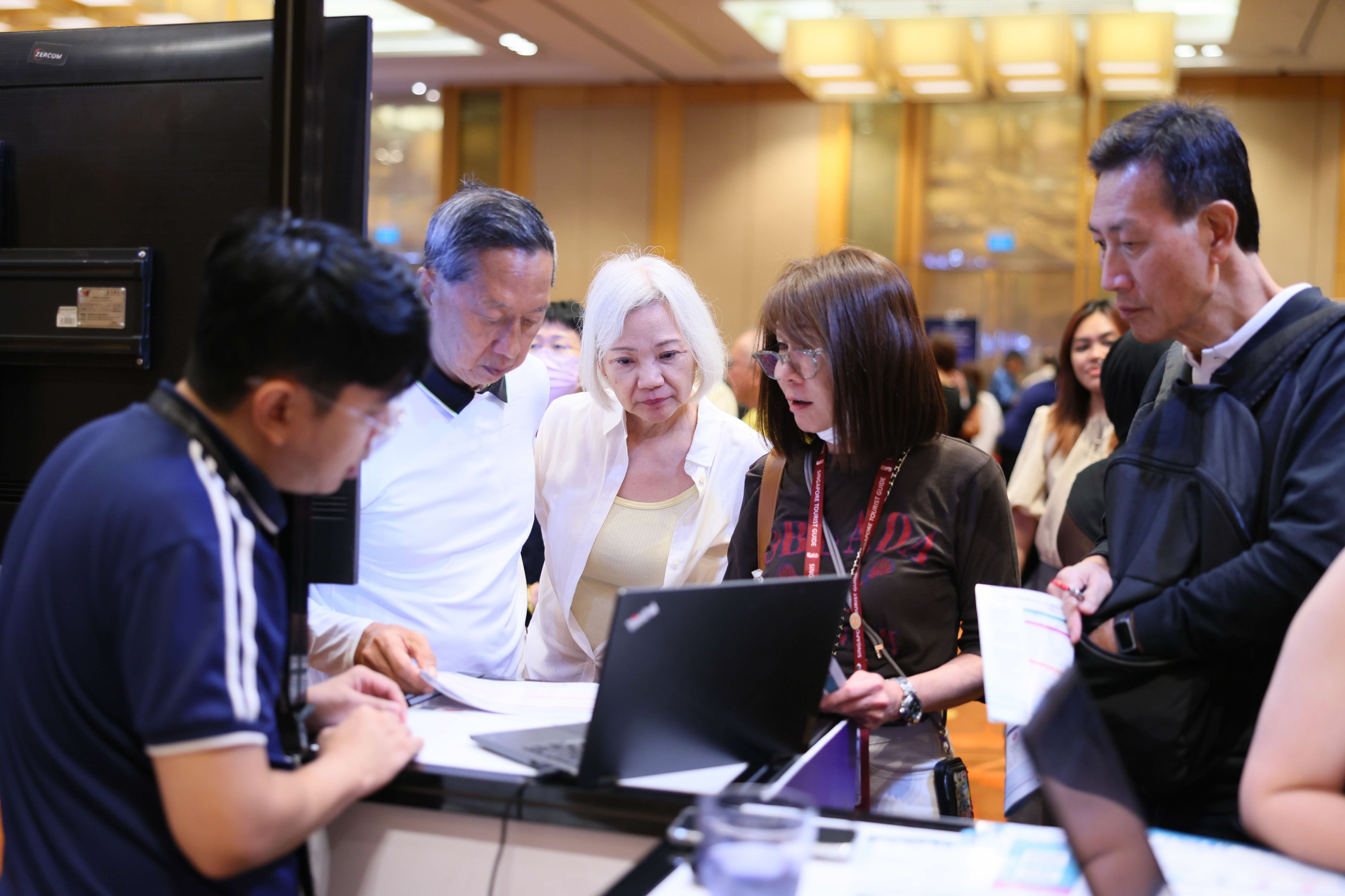 Travel agents interacting with vendors at the Elevate Zone booth.