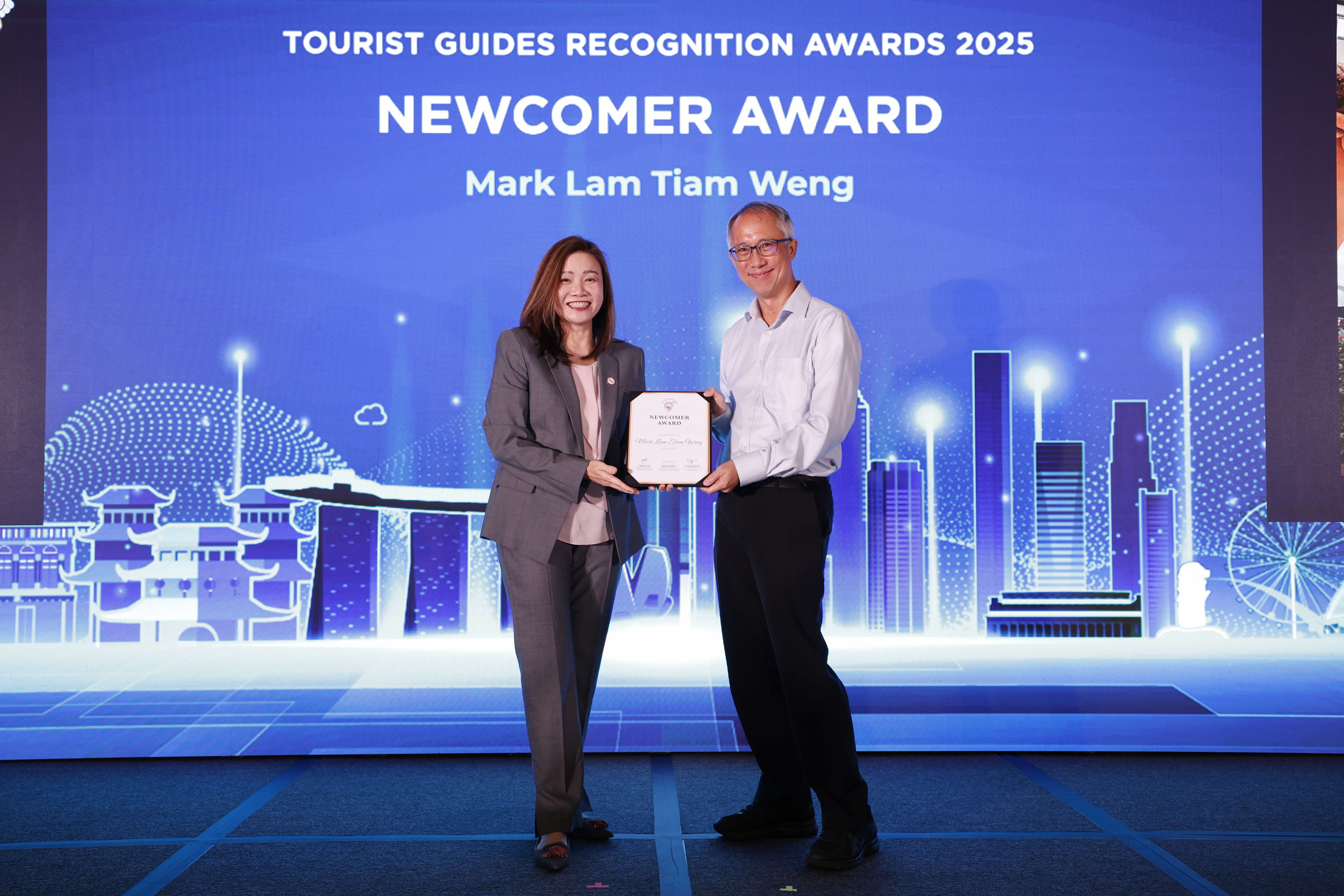 Mark Lam Tiam Weng receiving the Newcomer Award from STB Chief Executive Ms Melissa Ow.