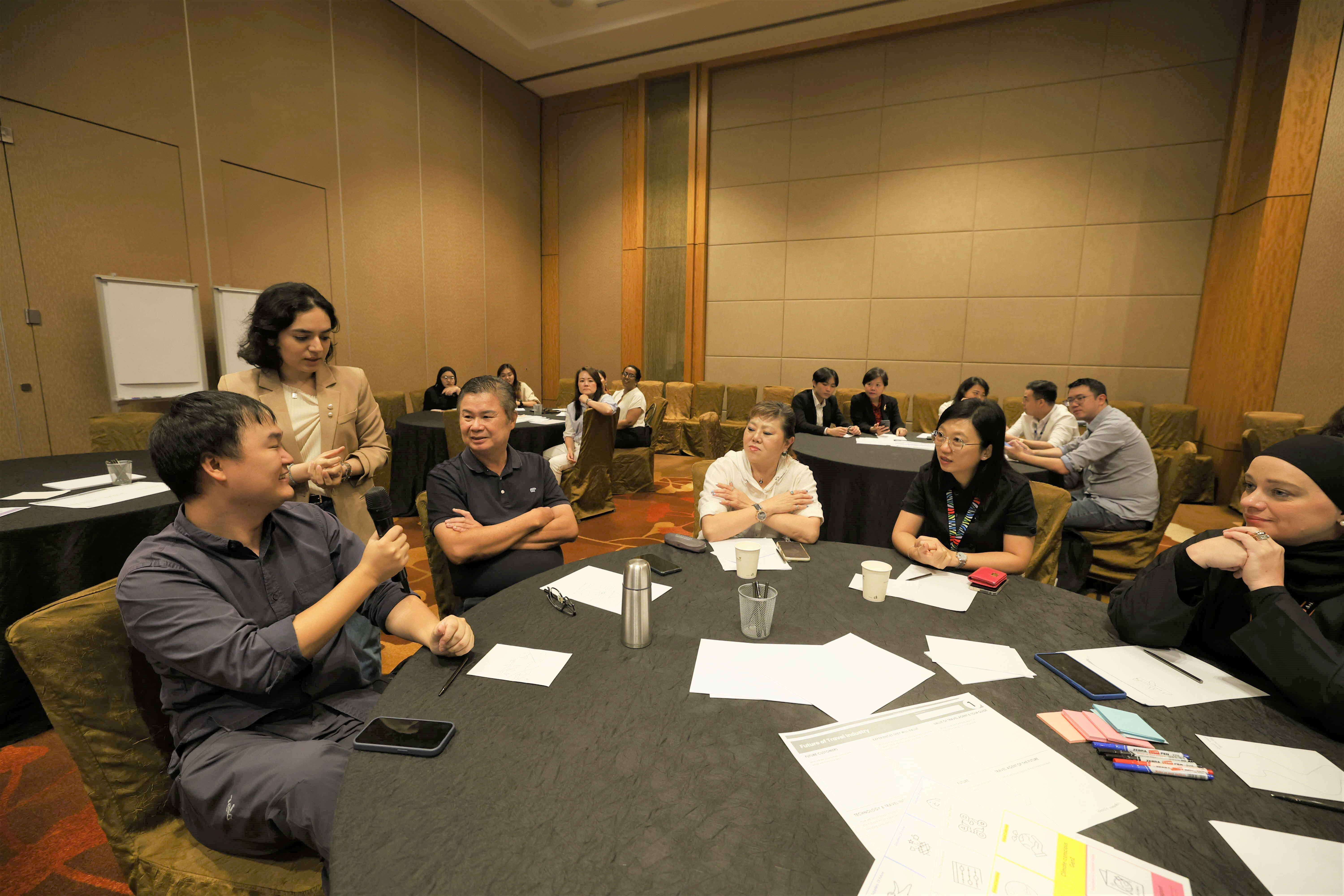 A travel agent attendee answering questions in an innovation-themed workshop.