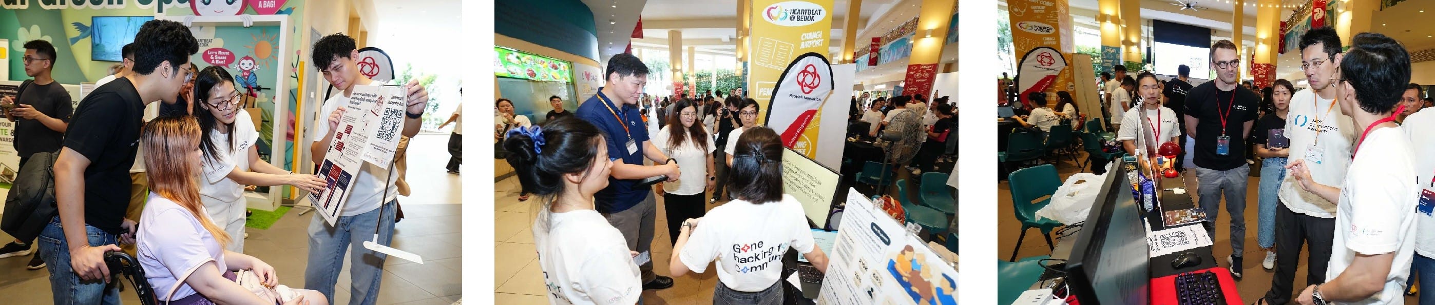 People are gathered in an indoor event space, some interacting with exhibits and others looking at posters and displays.