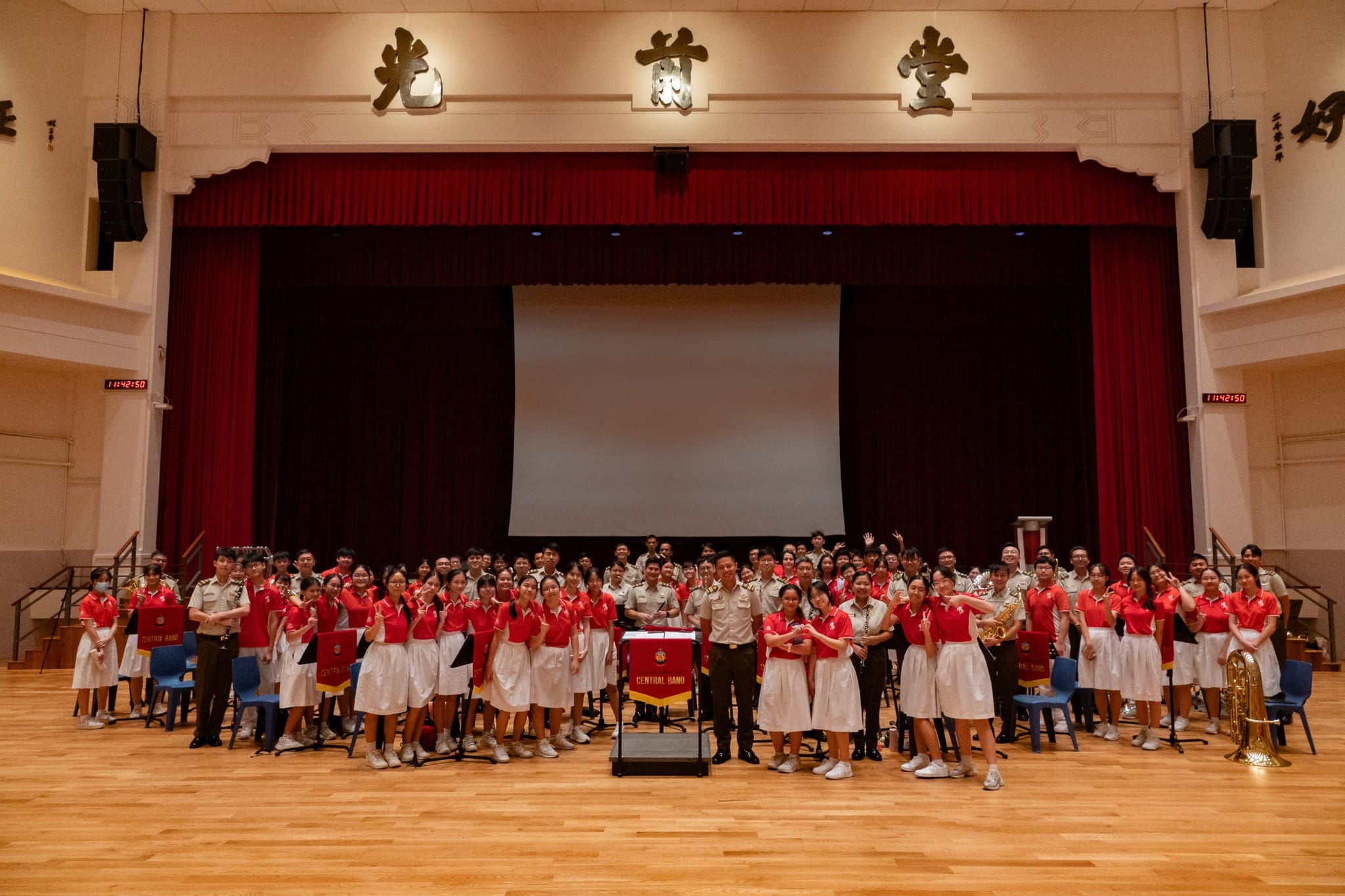 Students from CCHSM Concert Band and the SAF Central Band posing in a group photo.
