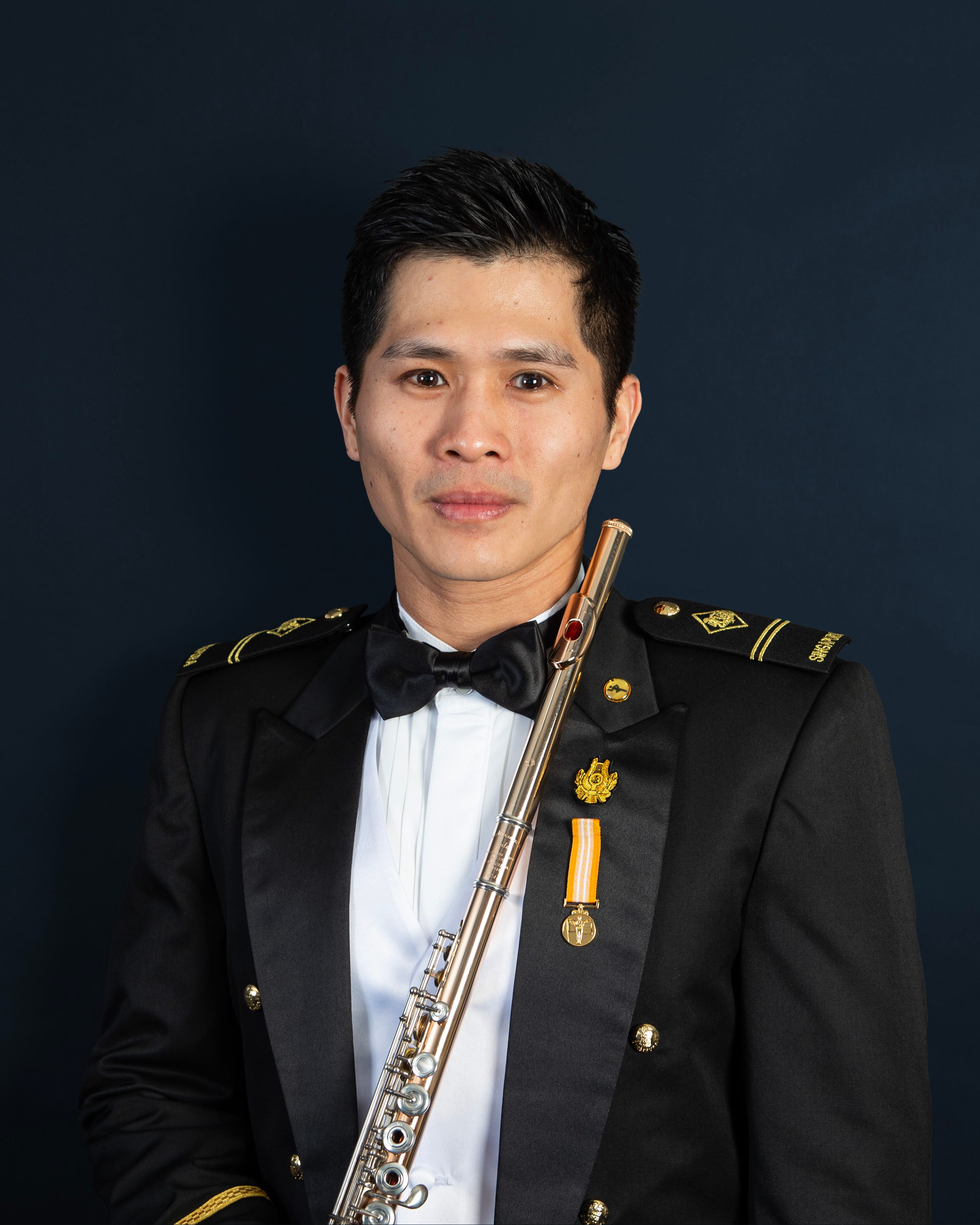 Portrait of ME2 Teo Shao Ming in uniform with a flute.