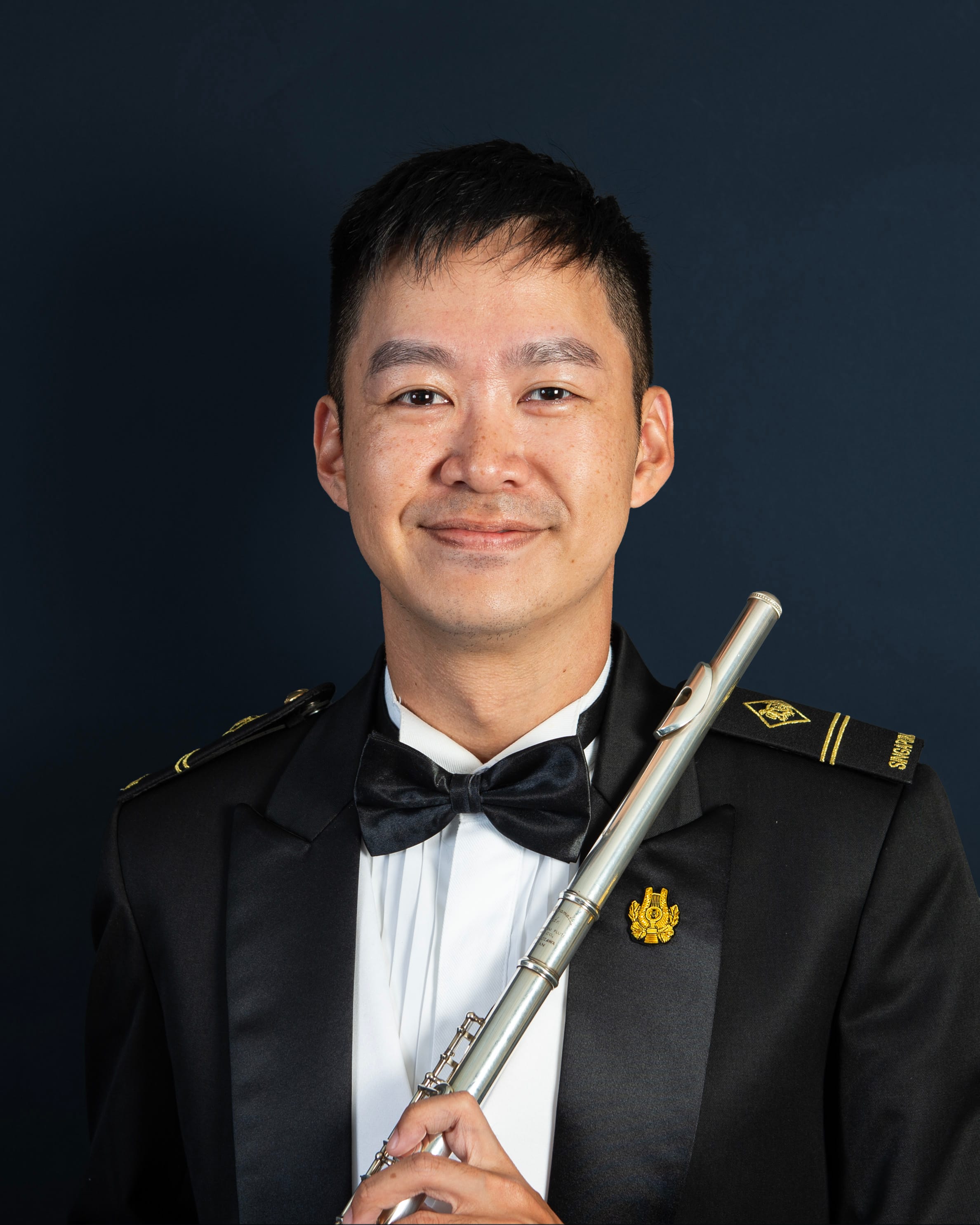 Portrait of ME2 Jasper Goh Chien Teng in uniform with a flute.