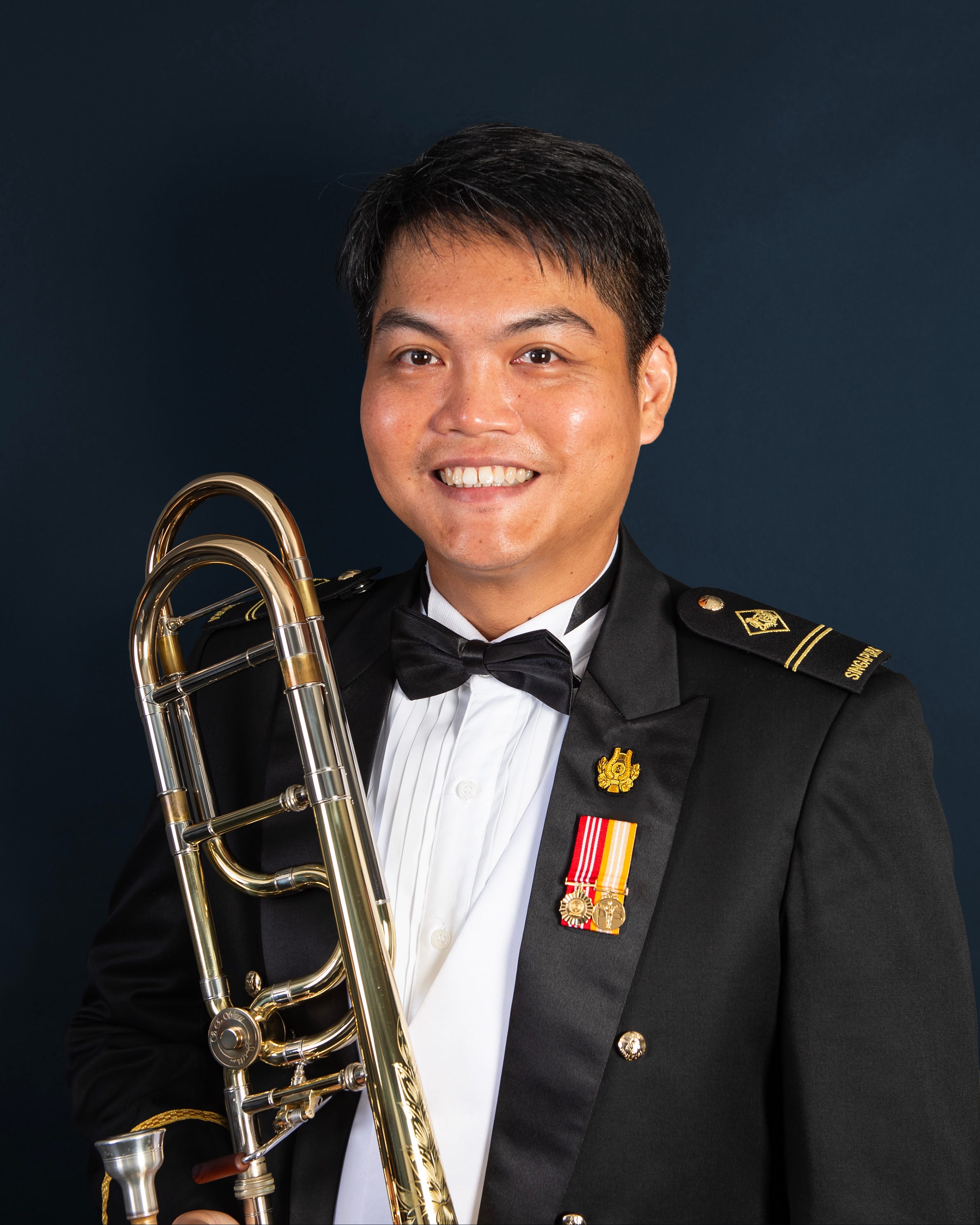 Portrait of ME2 Sebastian in uniform with a trombone.