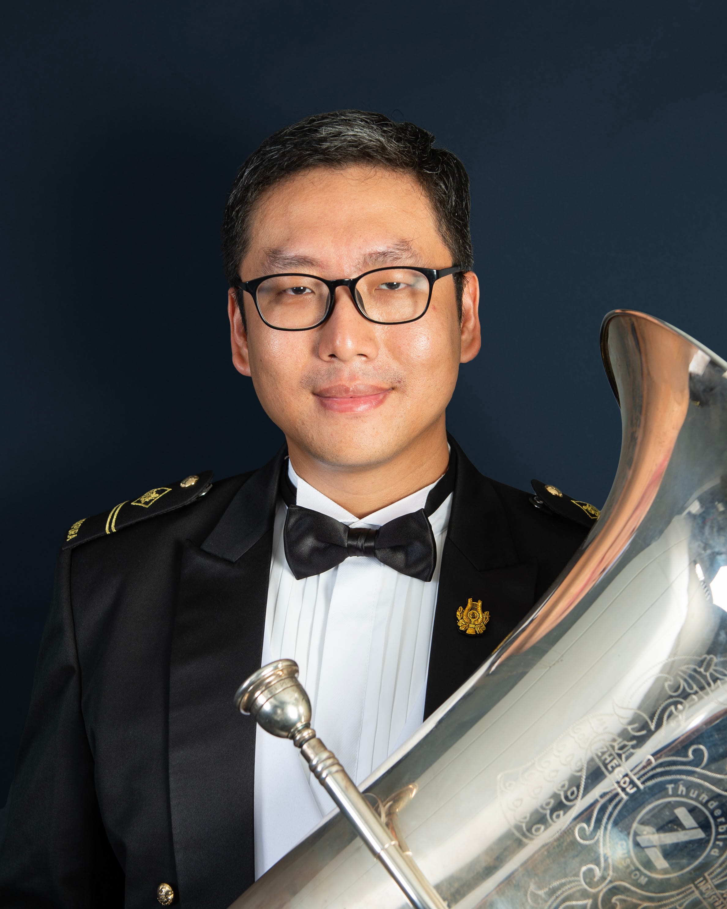 Portrait of ME2 Teng Siang Hong in uniform with a tuba.