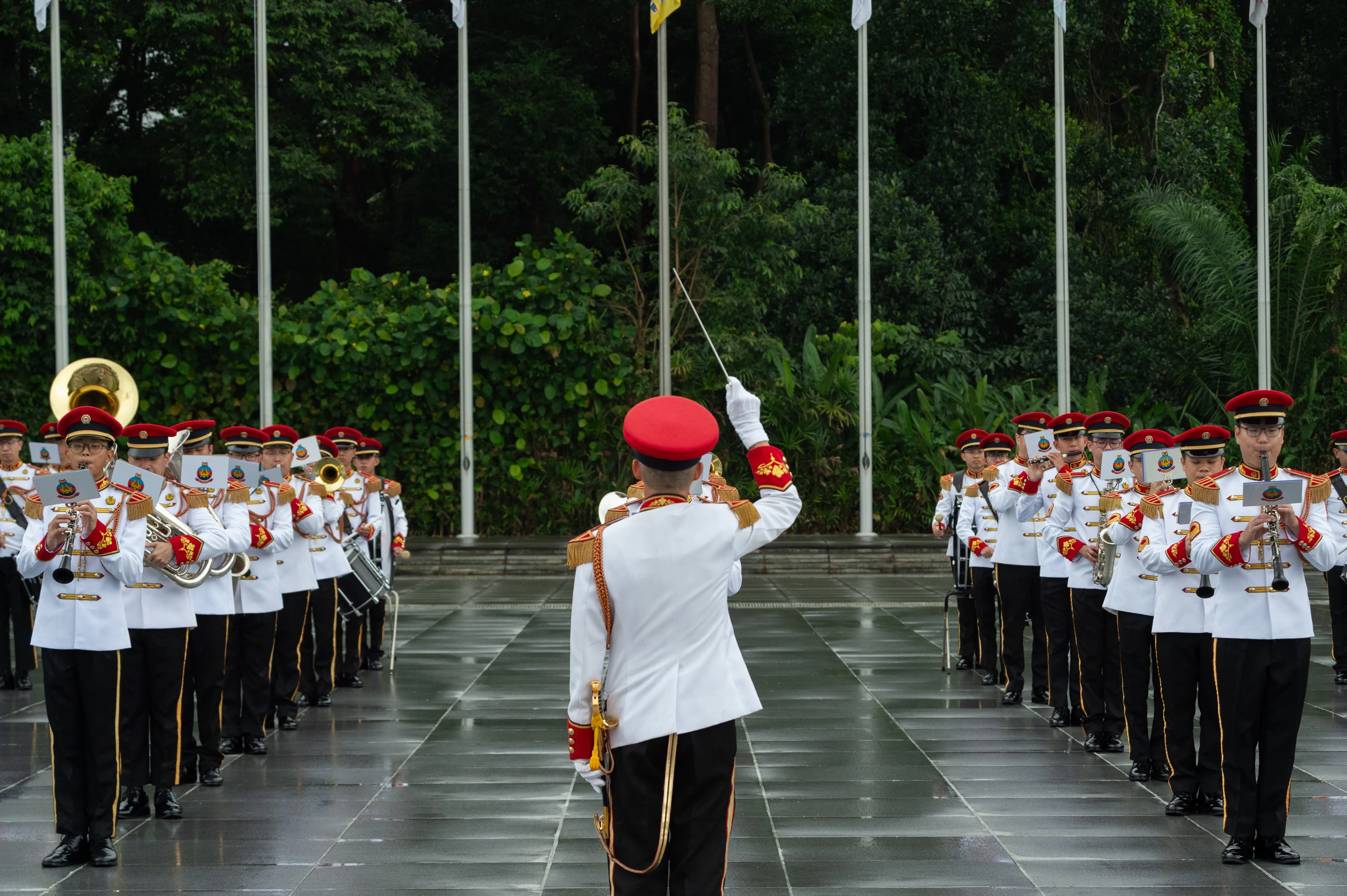 Band conductor in uniform conducting the band in an outdoor settings.