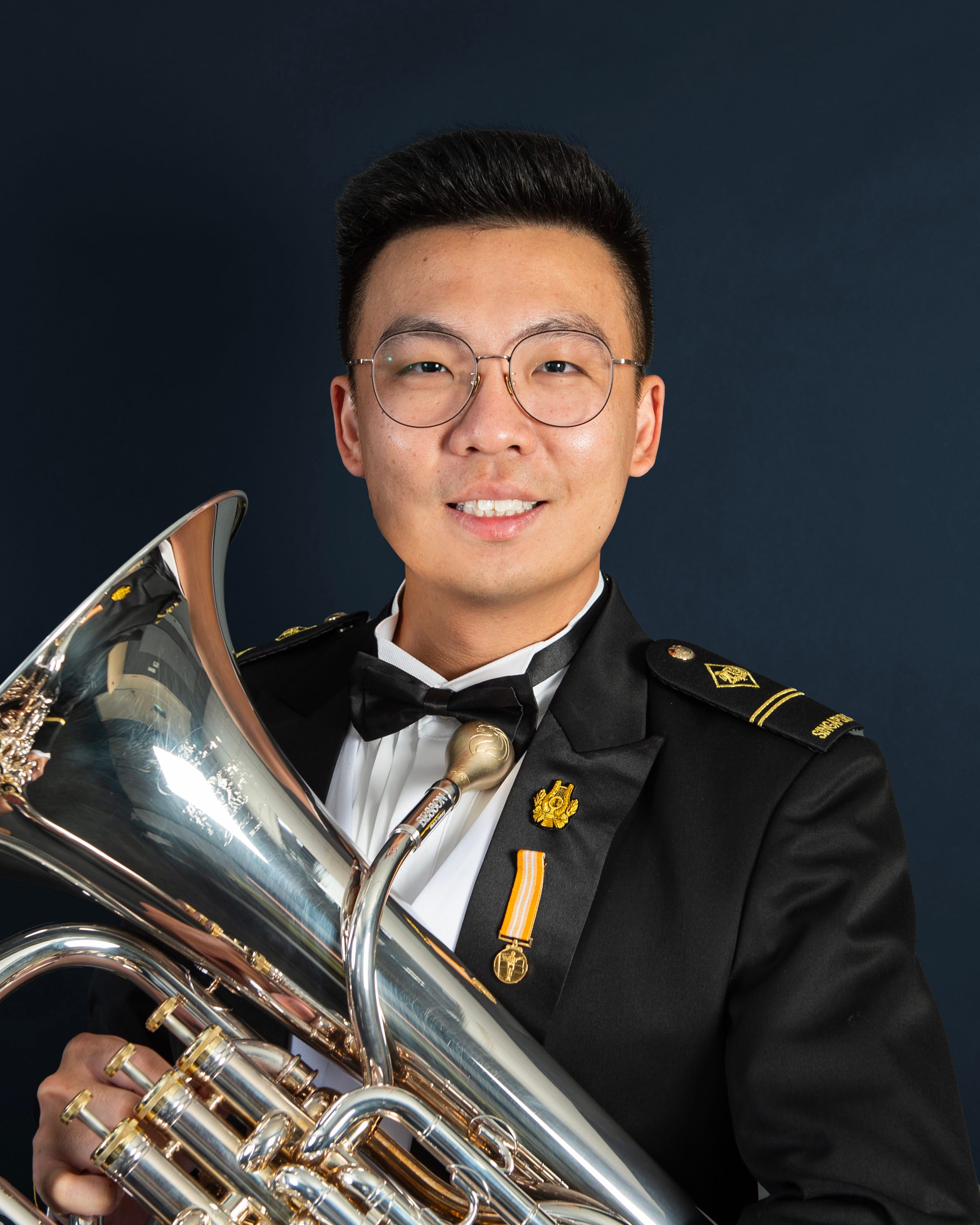 Portrait of ME2 Kang Chun Meng in uniform with a euphonium.
