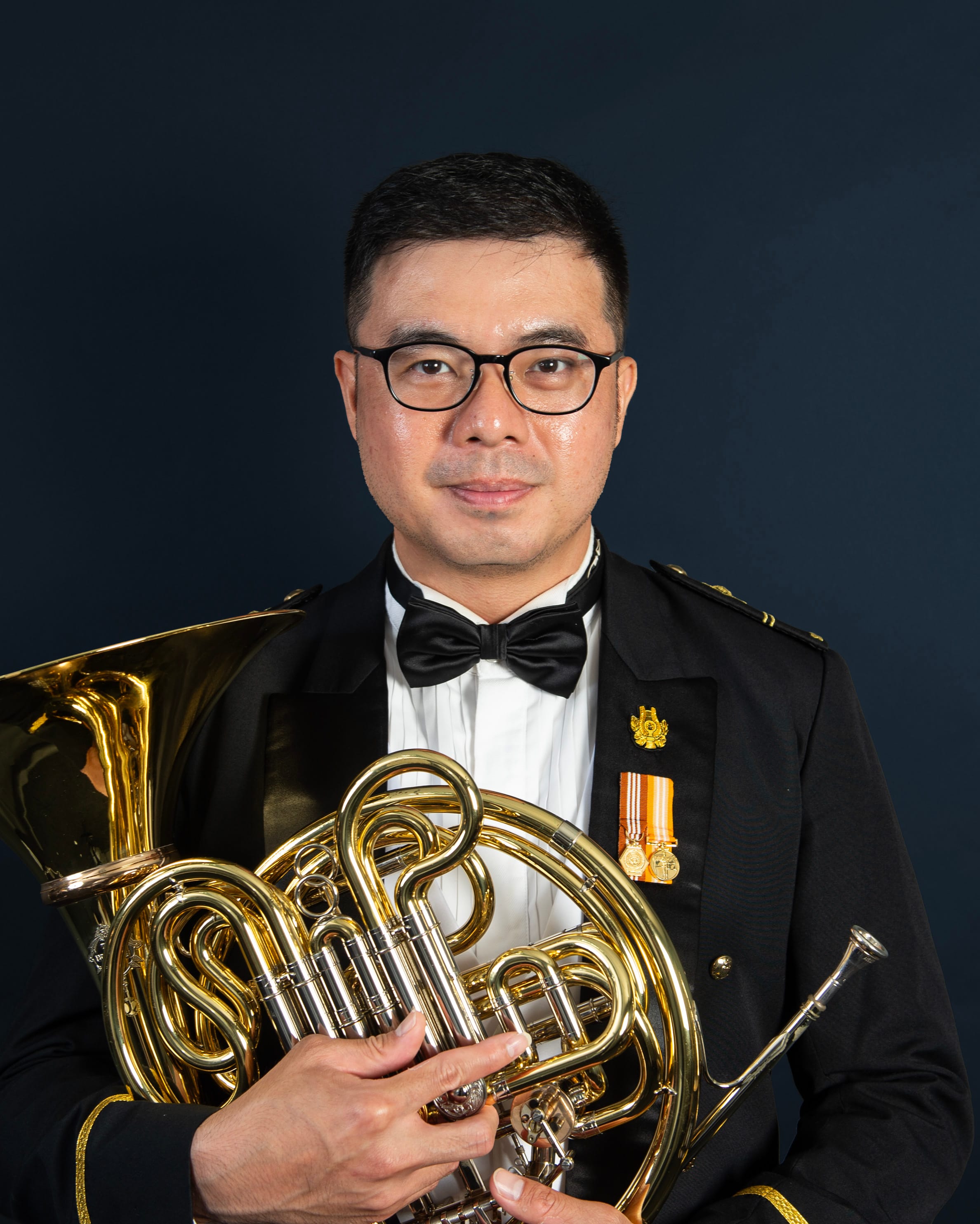 Portrait of ME2 Christopher in uniform with a french horn.