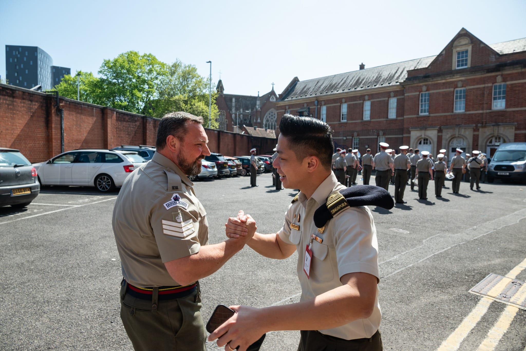 ME5 Wang receiving a hearty welcome from CSgt Chris Barnes while the RM Band Portsmouth rehearses in the background.