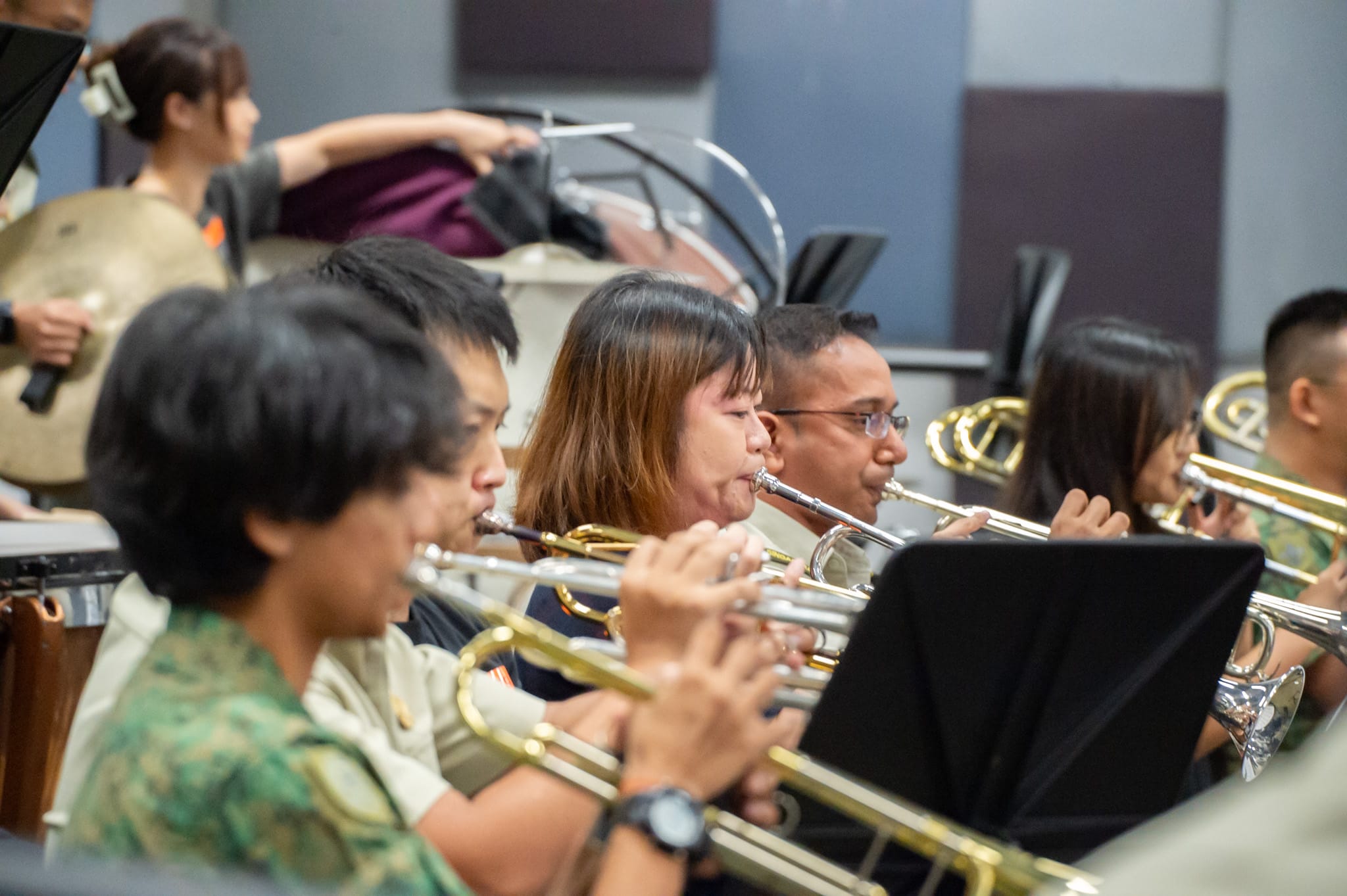 Musicians playing brass instruments in a military band practice.