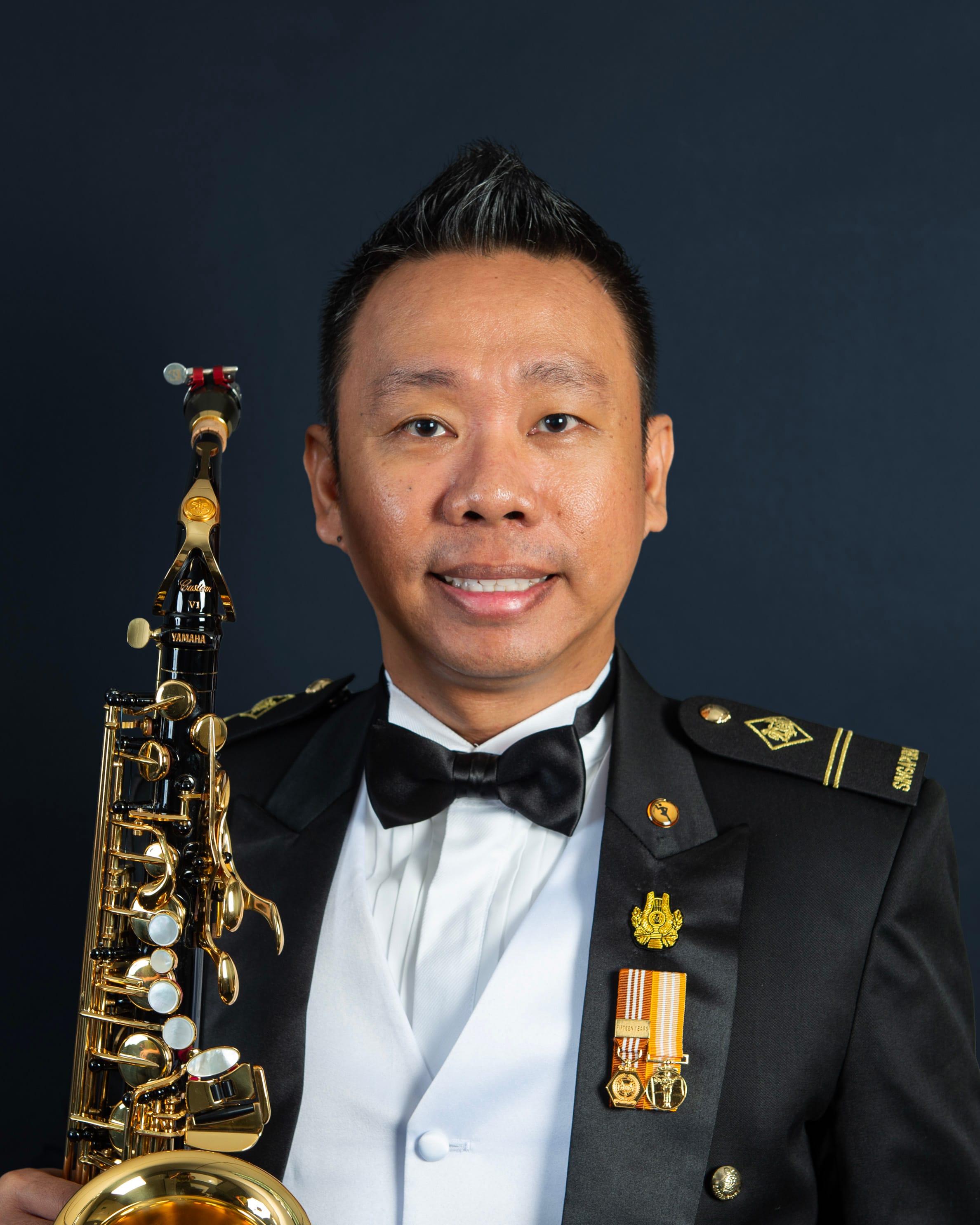 Portrait of ME2 Muhd Khairunnizam in uniform with a saxophone.