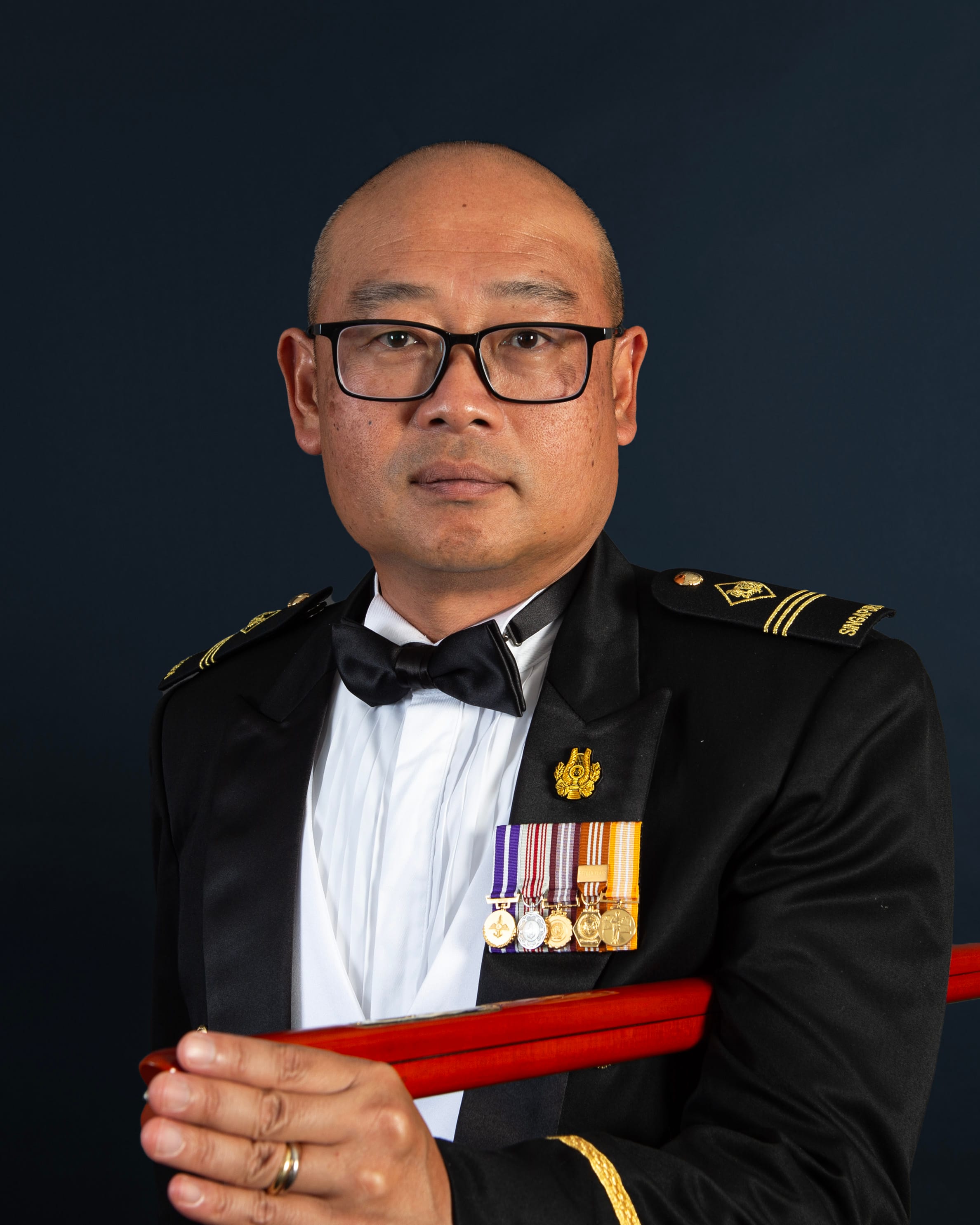 Portrait of ME3 Lim Wee Beng Gilbert in mess dress uniform with pace stick