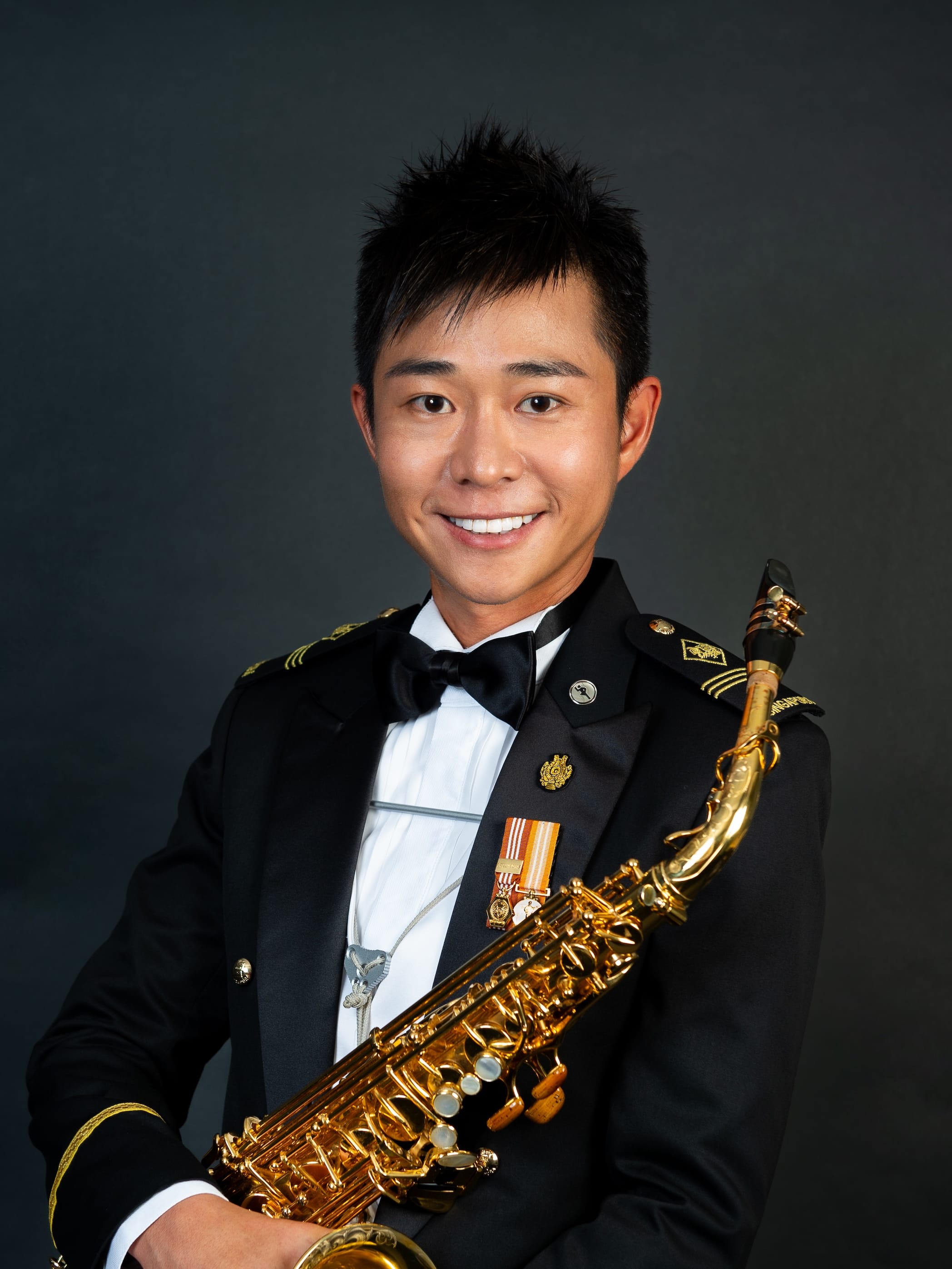Portrait of ME2 Zulhafeez in uniform with a saxophone.