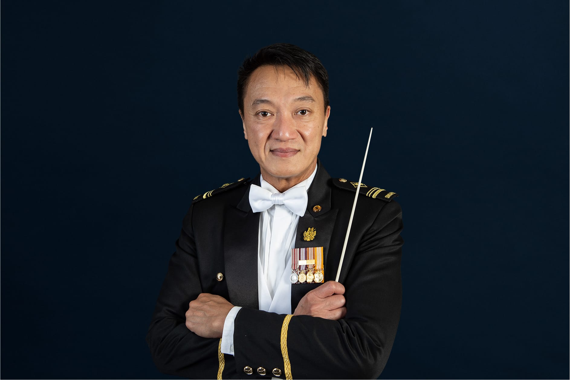 Portrait of ME5 Steven Ken in mess dress uniform with baton, featured on the SAF Central Band website.