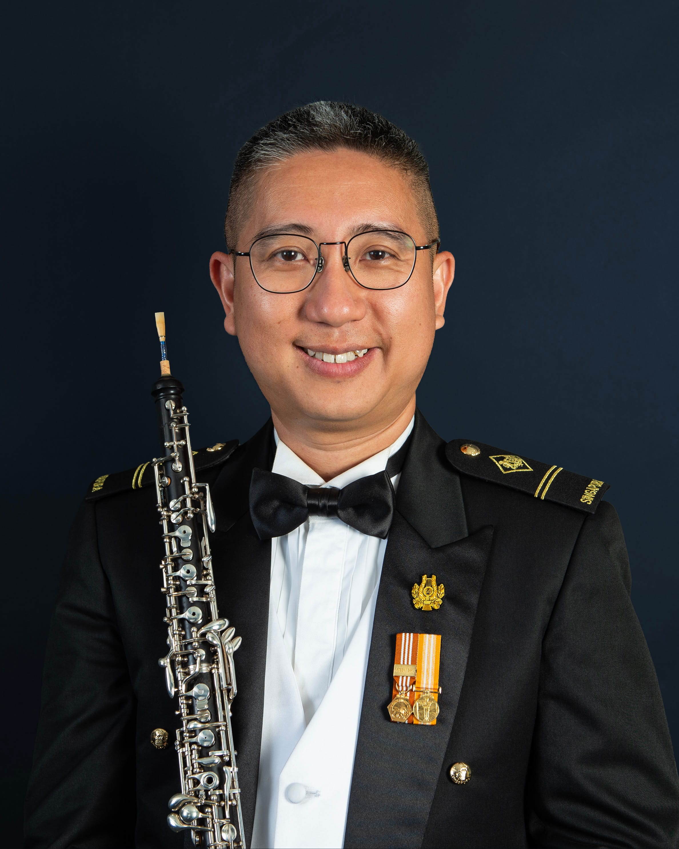 Portrait of ME2 Chew Wei Ren Justin in uniform with a oboe.