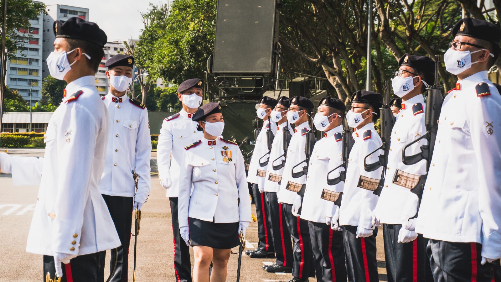 LTC Lim En inspects parade in ceremonial uniform with soldiers in white dress uniform.
