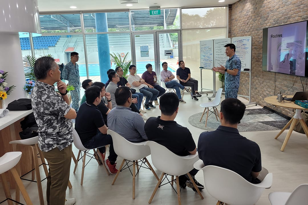 COL Oh leading a discussion in a casual workshop setting.