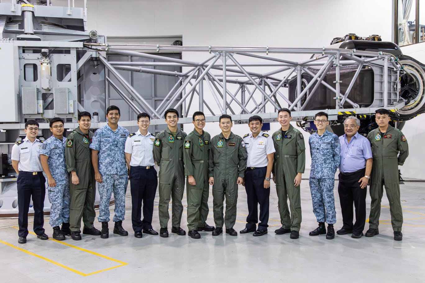Personnel from SAF and RSAF pose together at a maintenance or training facility.
