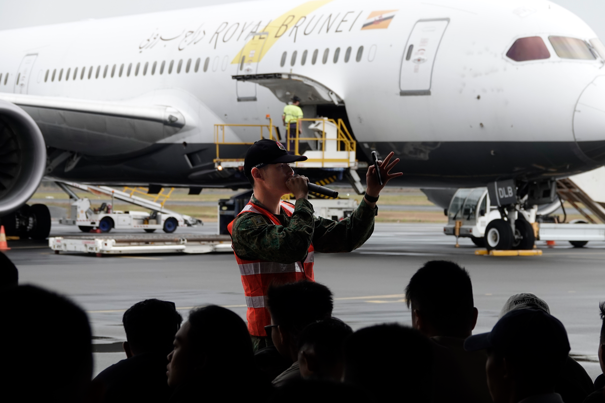 LTC Benjamin Tan addressing troops near a Royal Brunei aircraft.