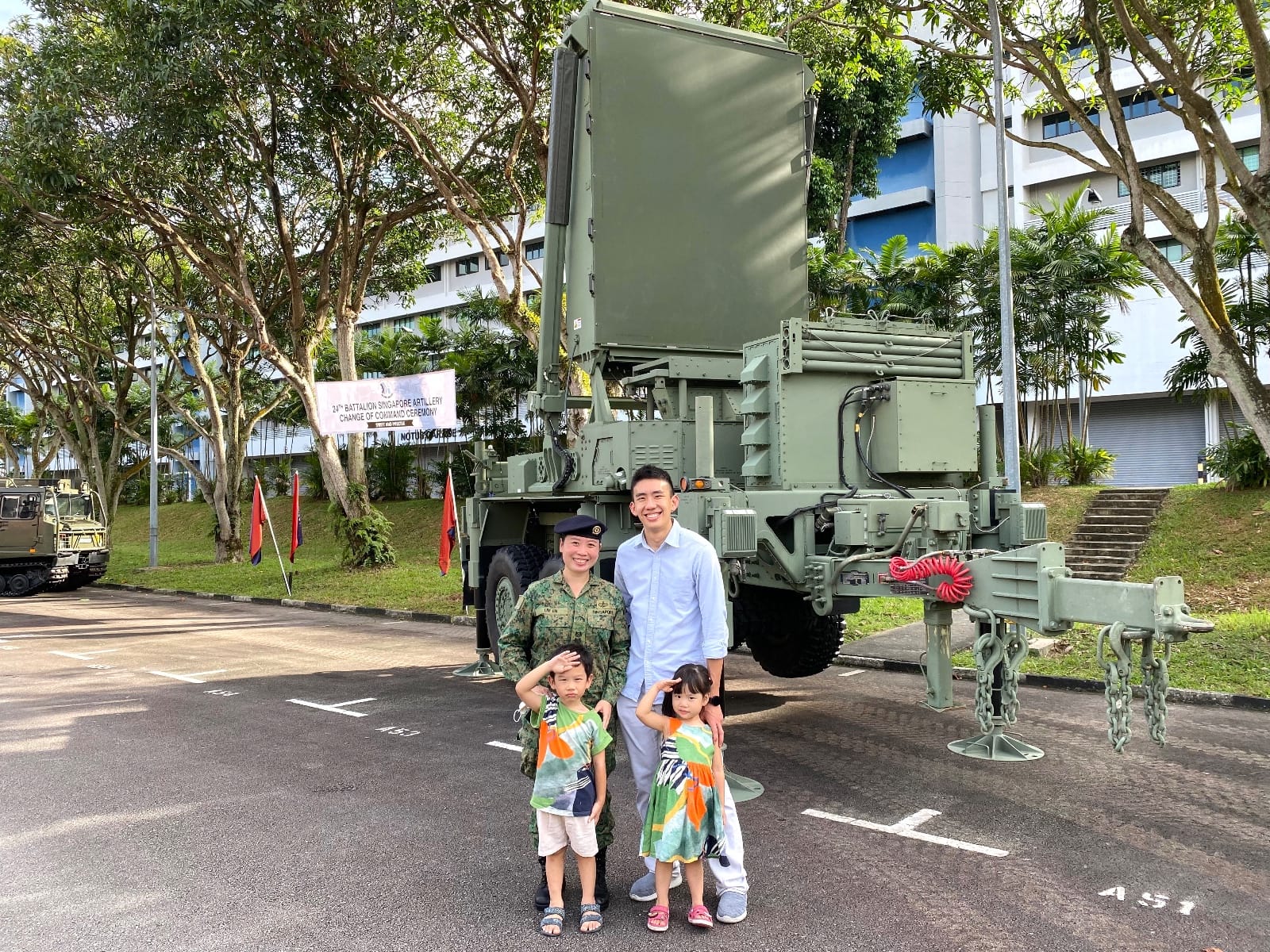 LTC Lim En with her family in front of a radar system at Change of Command ceremony.