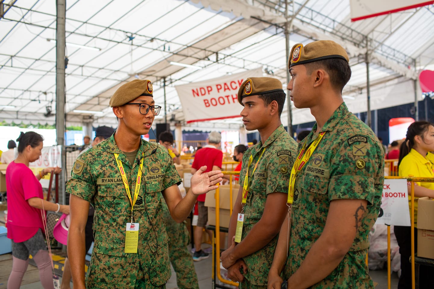 SAF soldiers being briefed by team leader at NDP pack distribution booth.