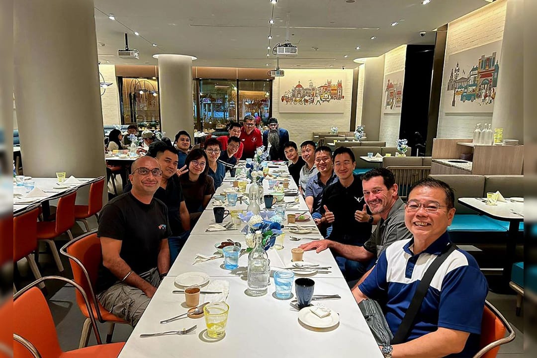 LTC Benjamin Tan and colleagues seated for a team dinner at a long table.