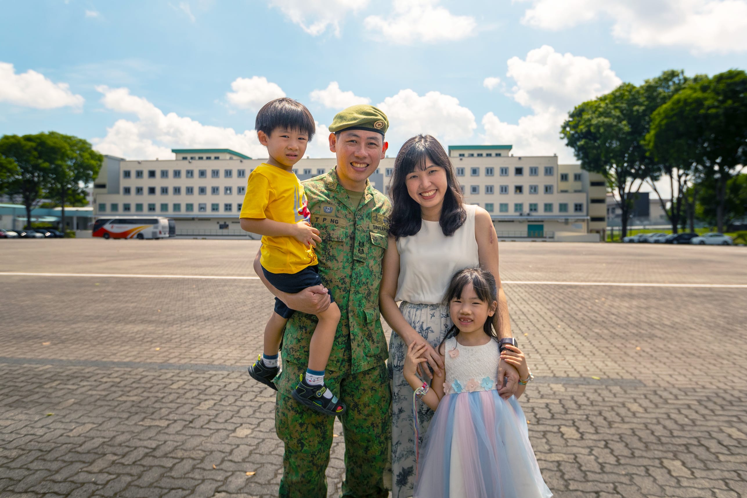 LTC Ng Tze Peng with his wife and two children at an army parade square.