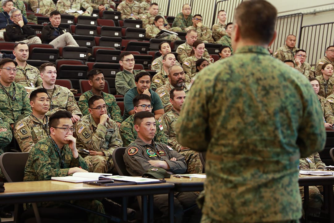COL Oh attending a multinational military lecture among uniformed personnel.