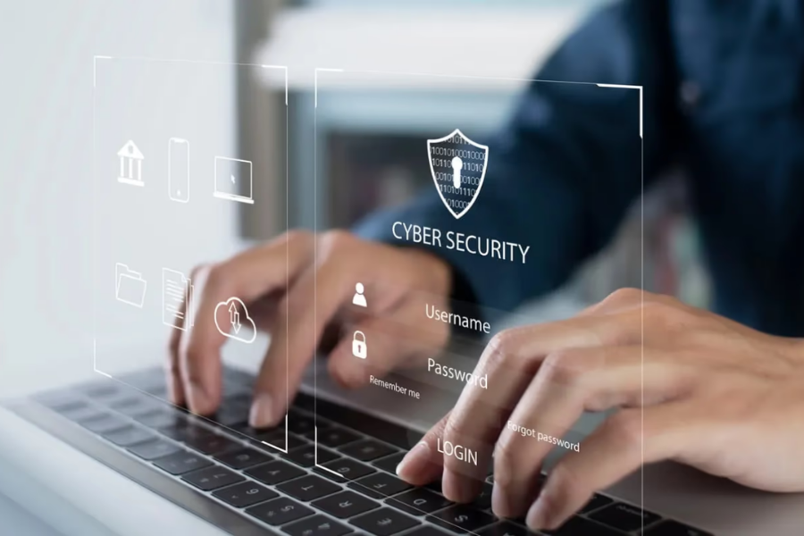 Hands typing on a laptop with cybersecurity interface for secure login.