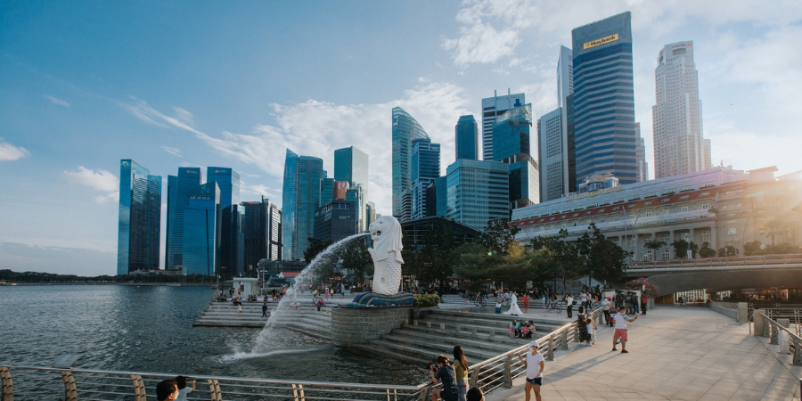 View of Singapore's skyline with modern skyscrapers and the Merlion statue at Marina Bay.