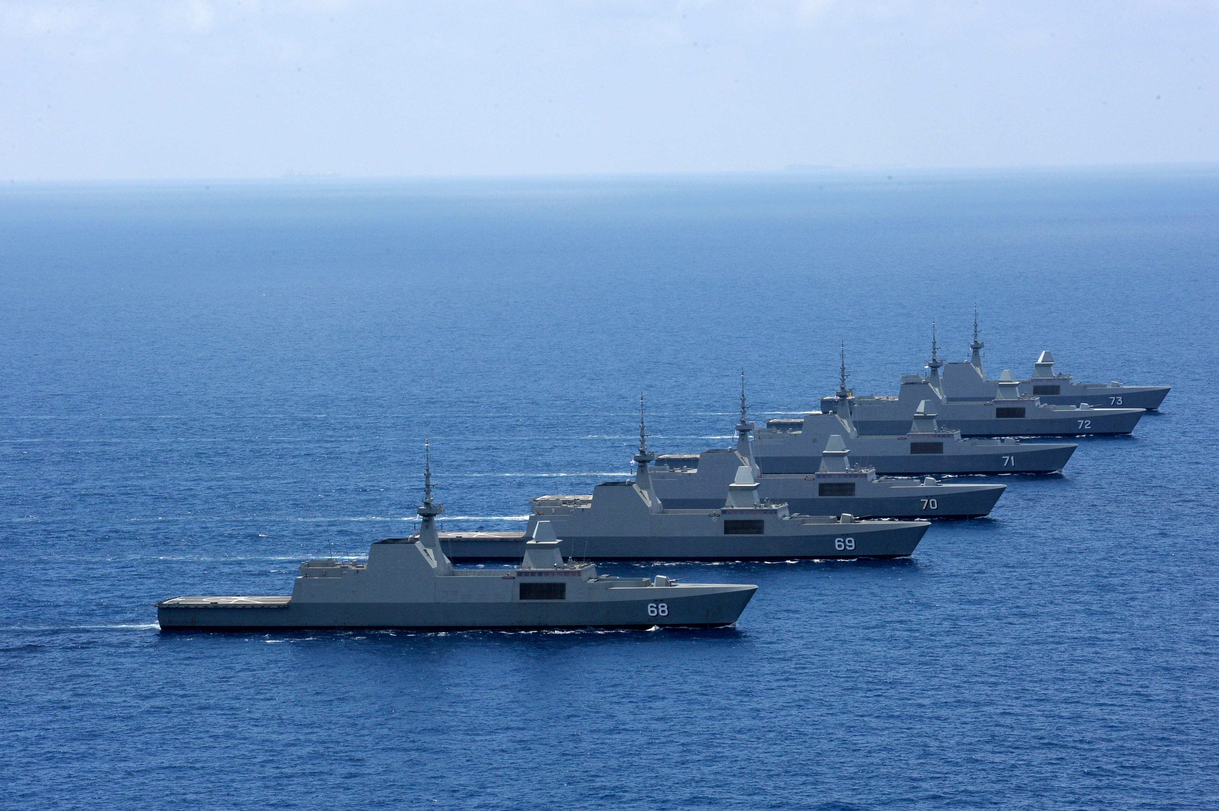 A frigate sailing in open waters, with the blue sea stretching out into the distance.