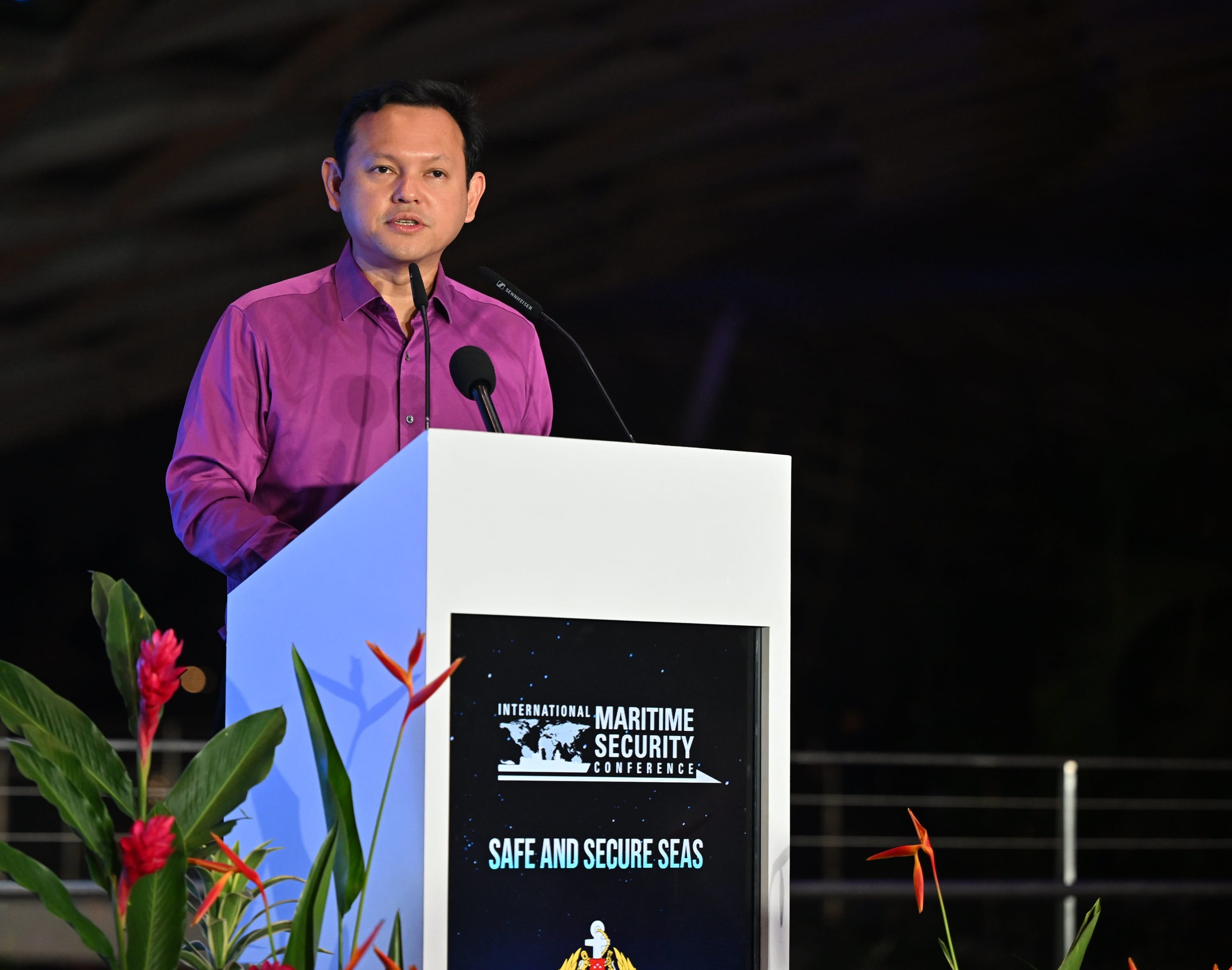 Man in a magenta shirt speaking at "International Maritime Security Conference".