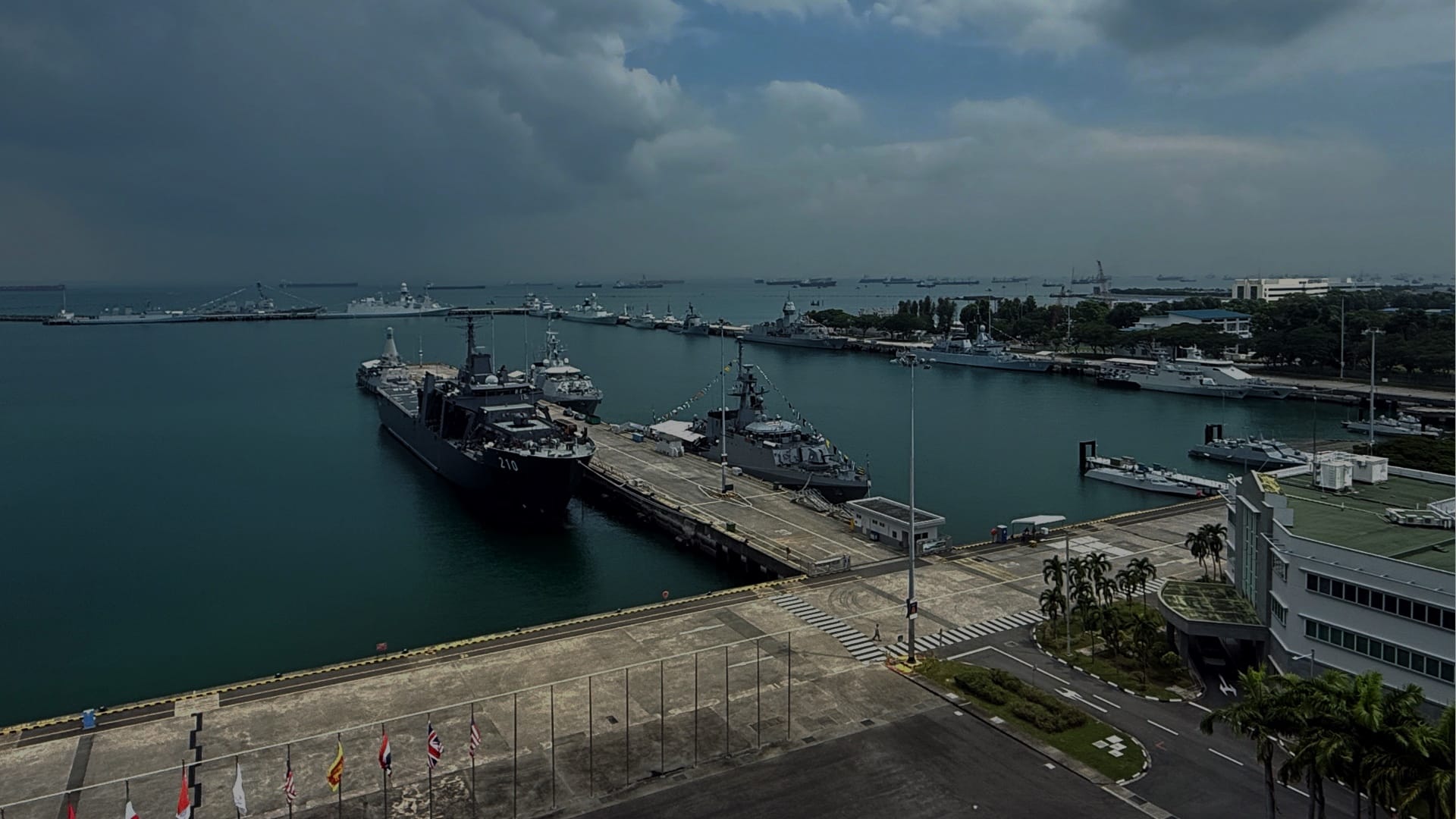 Naval vessels docked at Changi Naval Base during IMDEX Asia under cloudy skies.