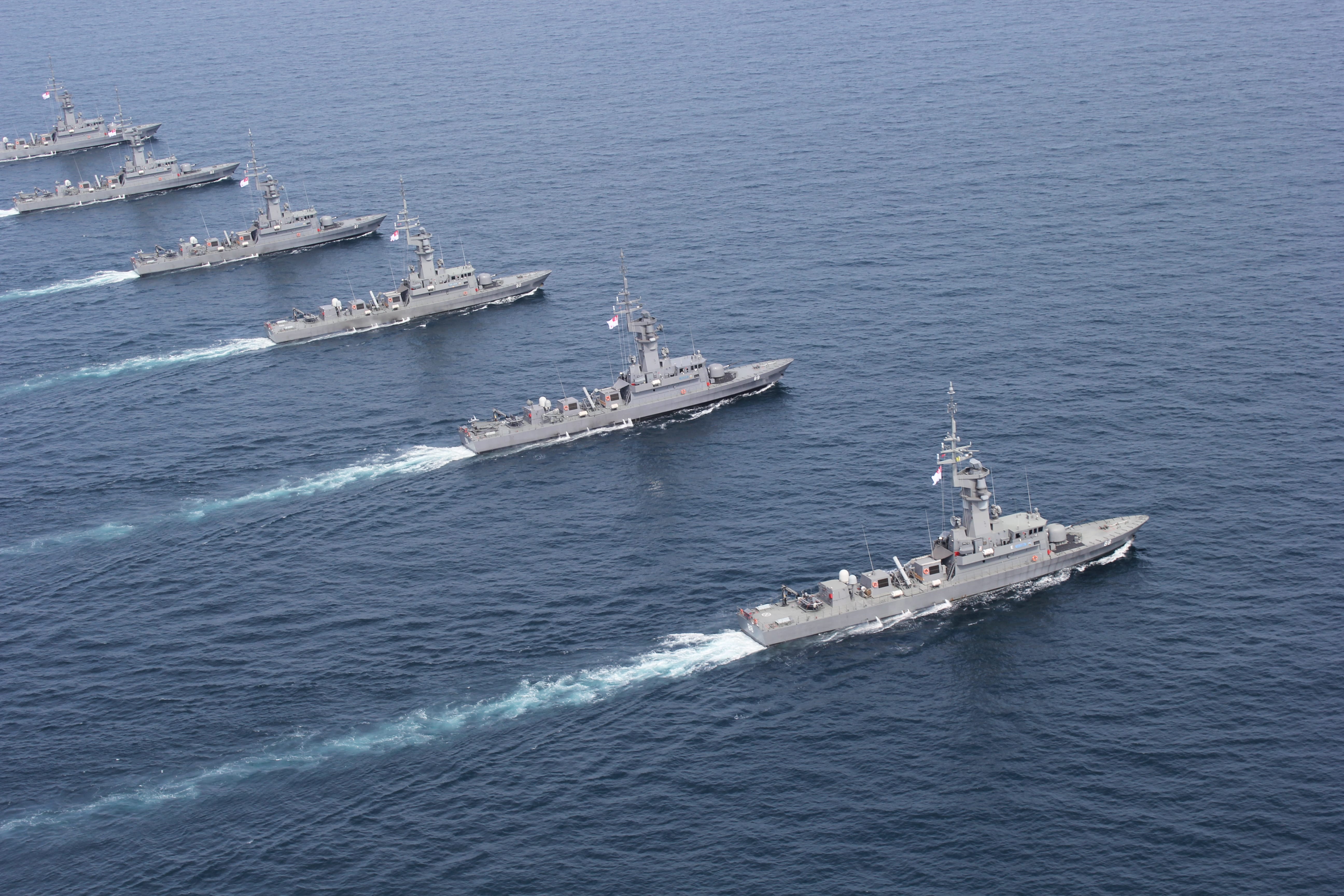 A group of Singapore Navy ships sailing in formation across the sea.
