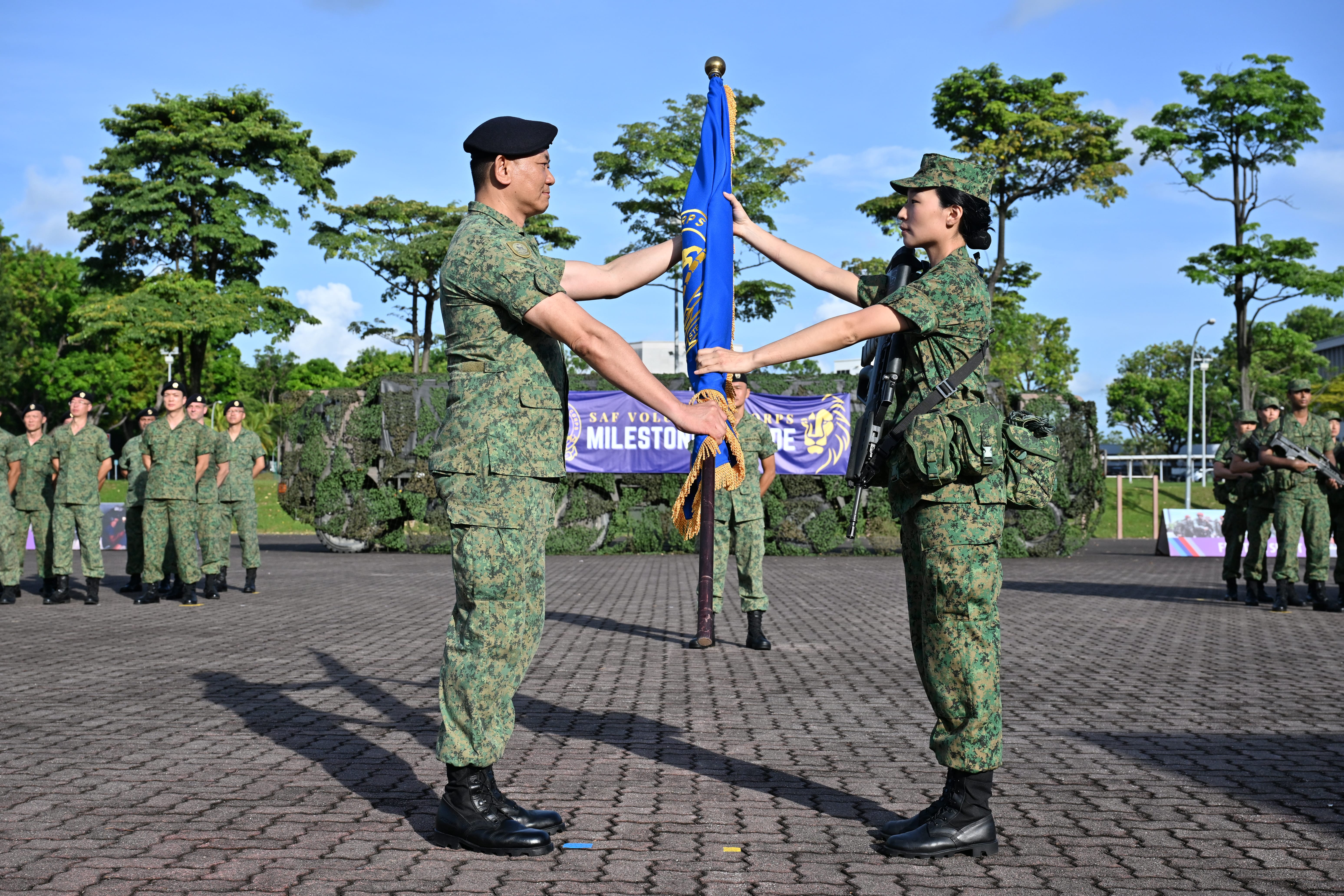 SV(T) Sim Cai Yu (right) receiving the SAFVC Flag from ex-SV3 Ong Kok Keng (left) in a symbolic handing and taking over during the Milestone Parade at Maju Camp earlier today.