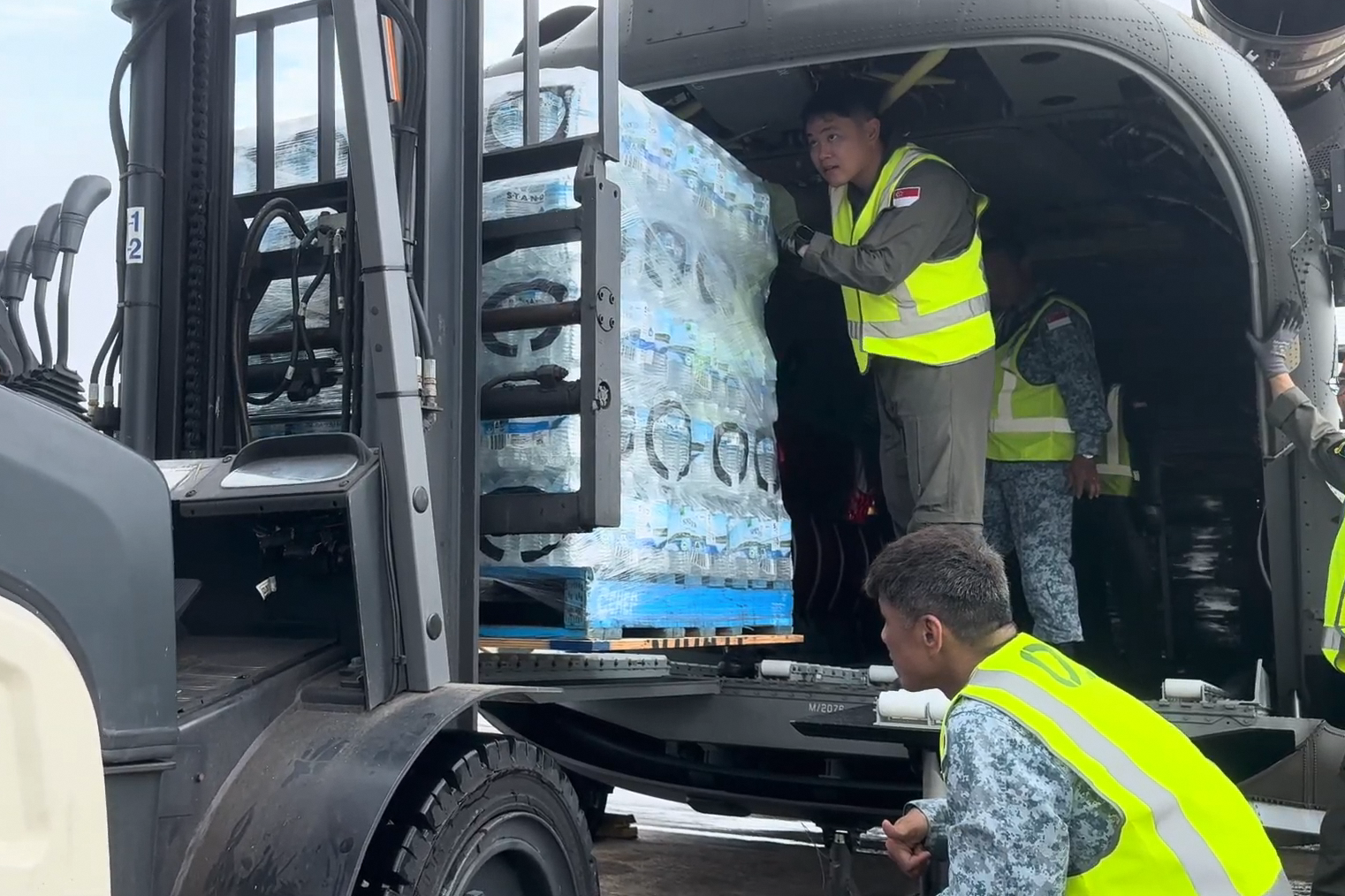 RSAF personnel loading supplies on the CH-47F helicopter for the flood-affected areas.