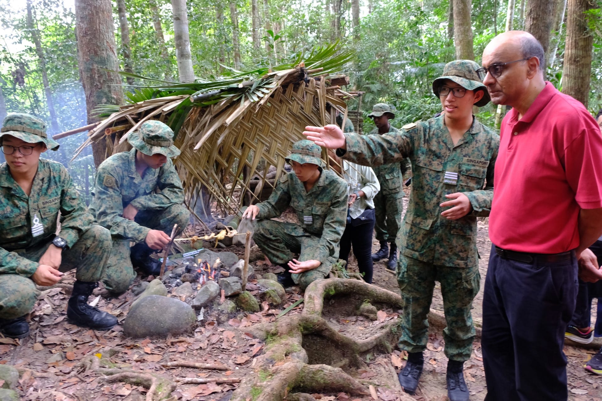 President Tharman (far right) viewing Officer Cadets (OCTs) building a fire as part of their jungle confidence and survival training in Brunei.