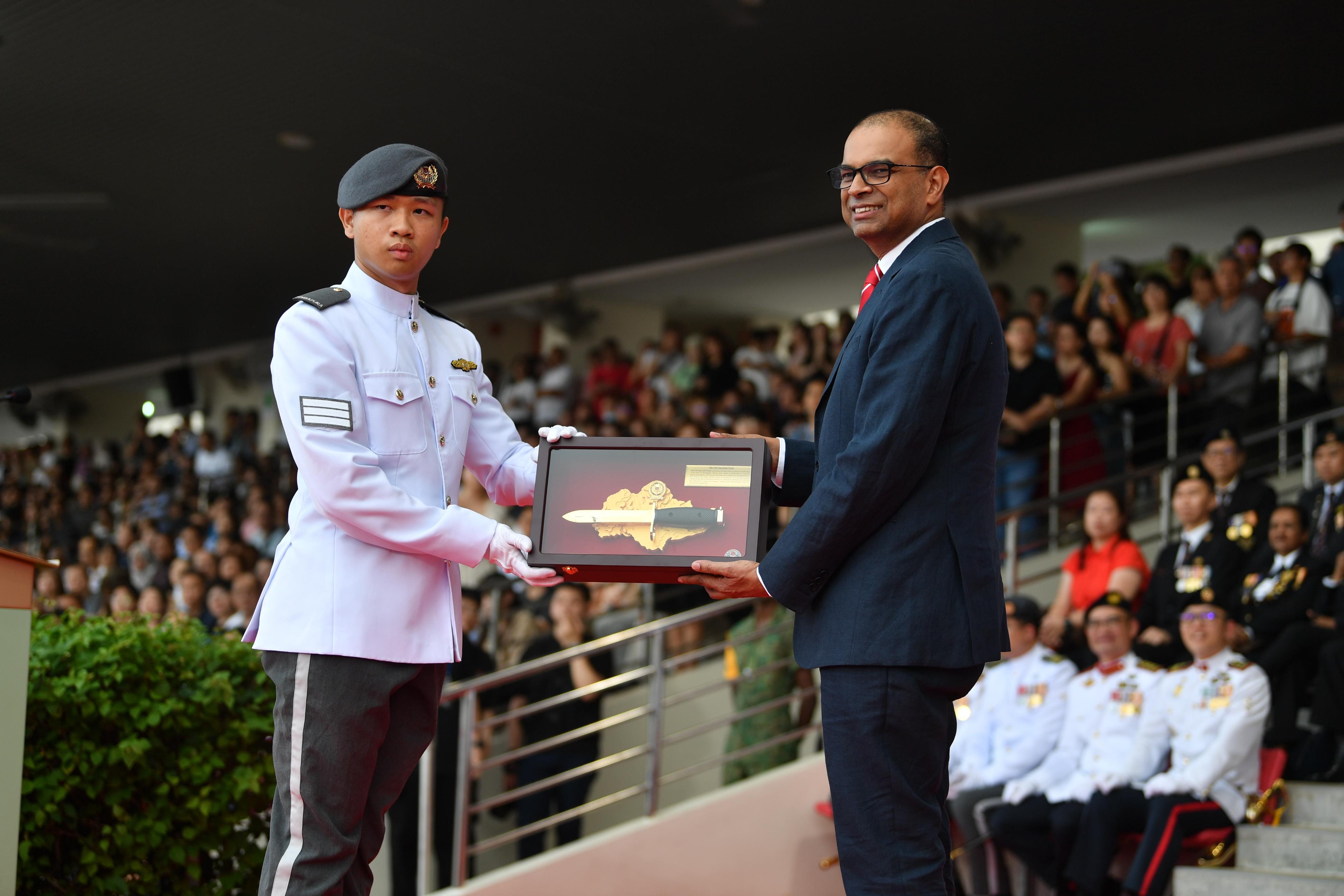 Dr Janil presenting the Golden Bayonet to 3SG Tng Guang Hong, Zak from the Digital and Intelligence Service during the graduation parade.