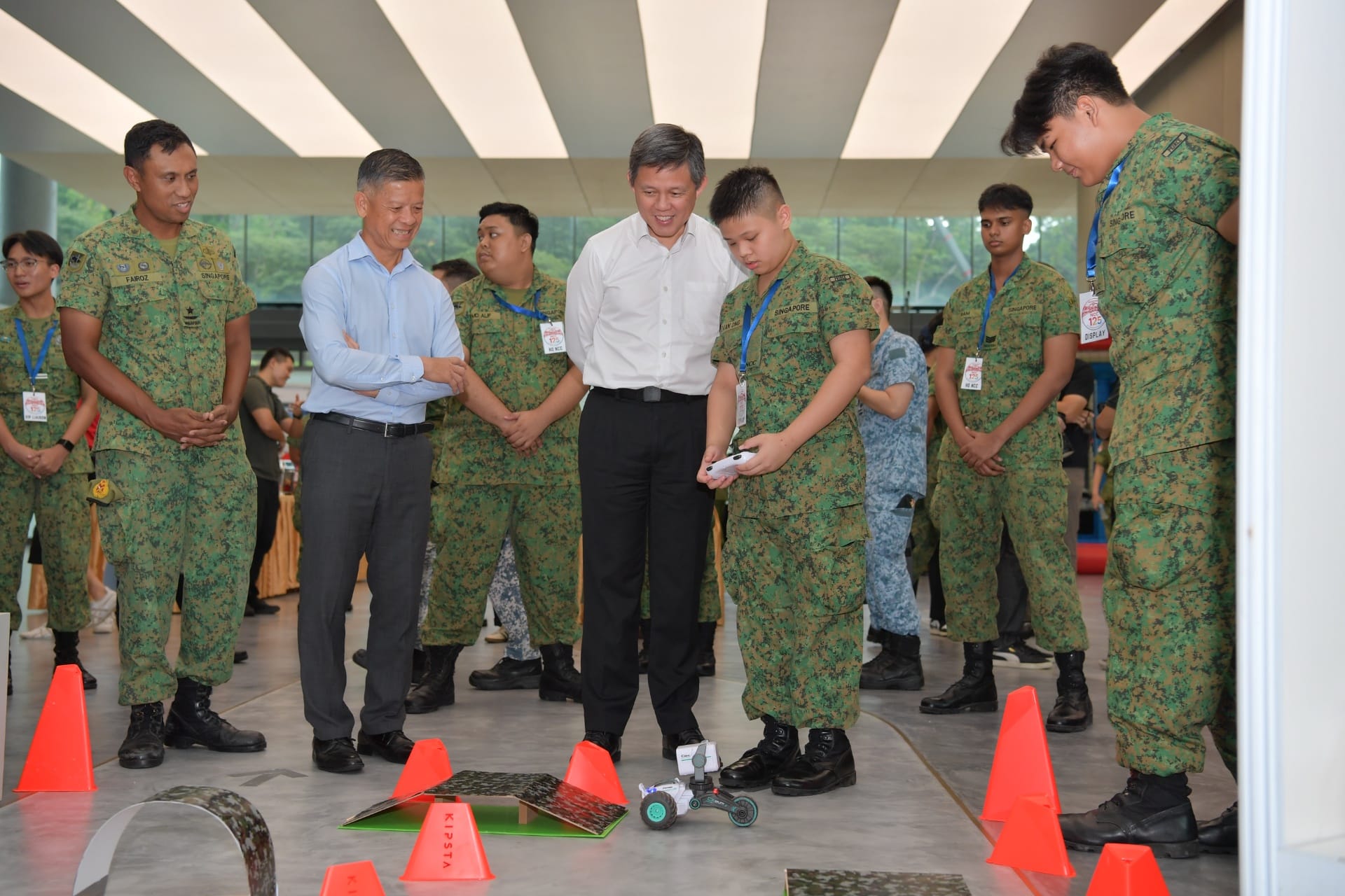 Minister Chan interacting with students at a display booth.