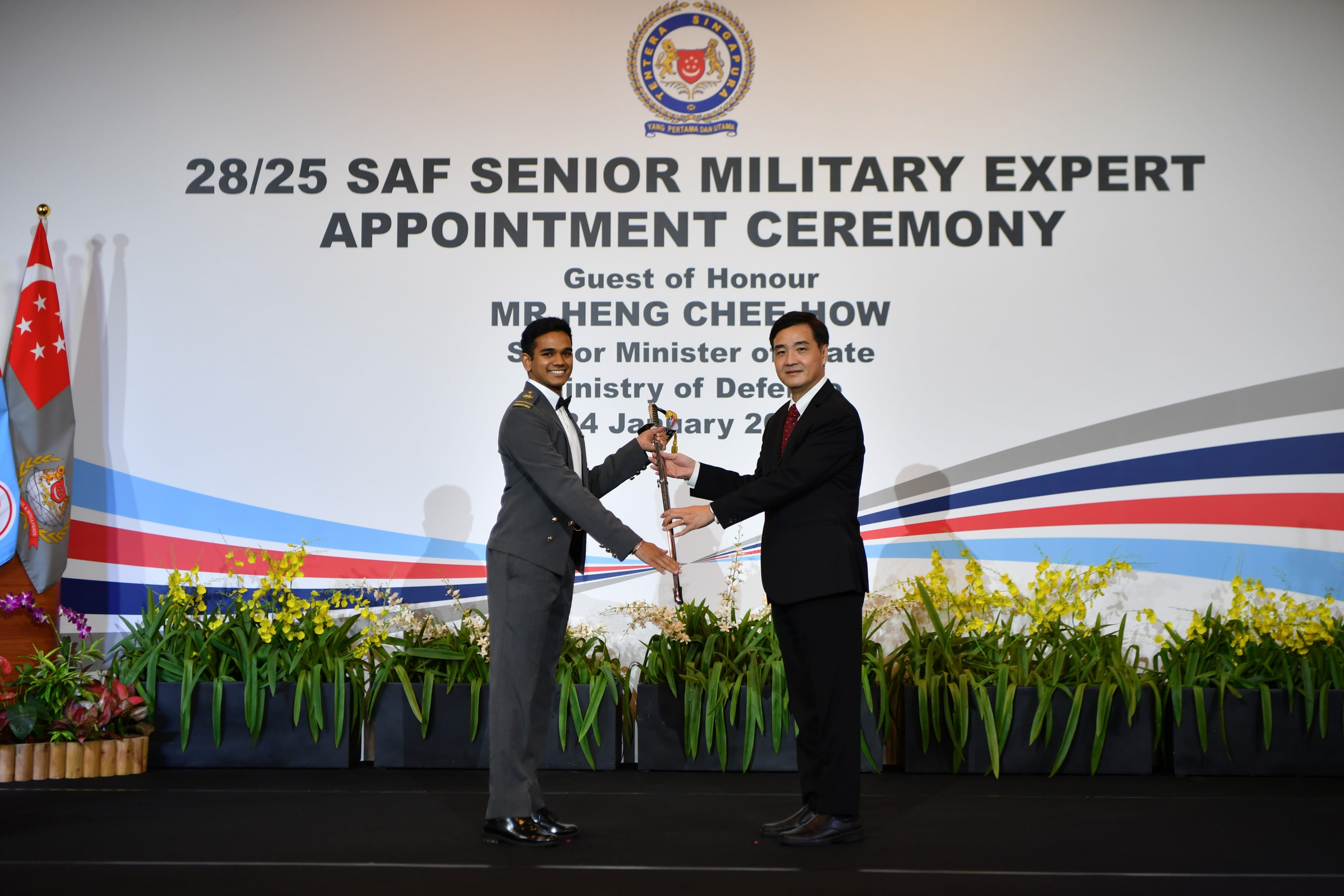 Senior Minister of State for Defence Mr Heng Chee How (right) presenting the Sword of Honour to ME4 Yoga Keshnen S/O Yogindean (left) at the 28th SMEAC.