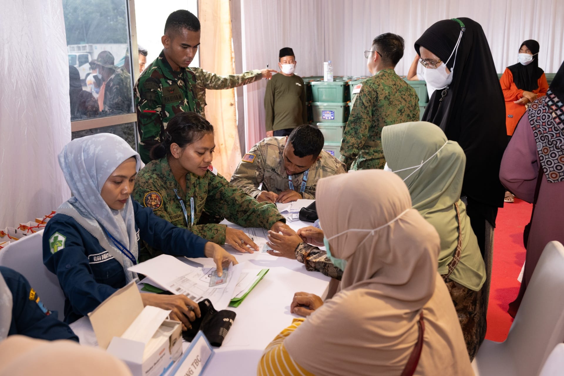 Military and civilian health personnel facilitating health screenings for local residents during XTR's community health activities in Banten, Indonesia.