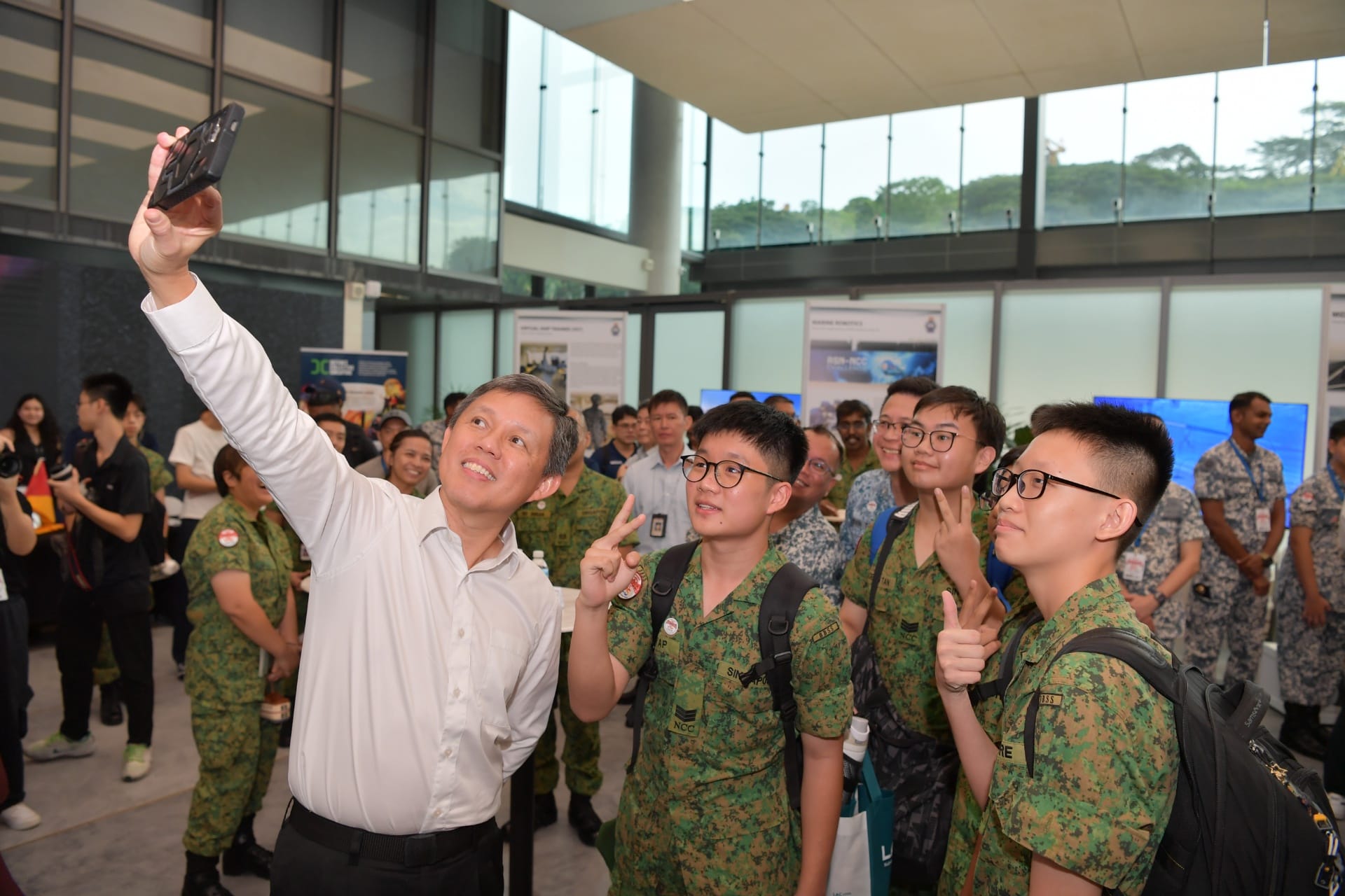 Minister Chan taking a photo with students.