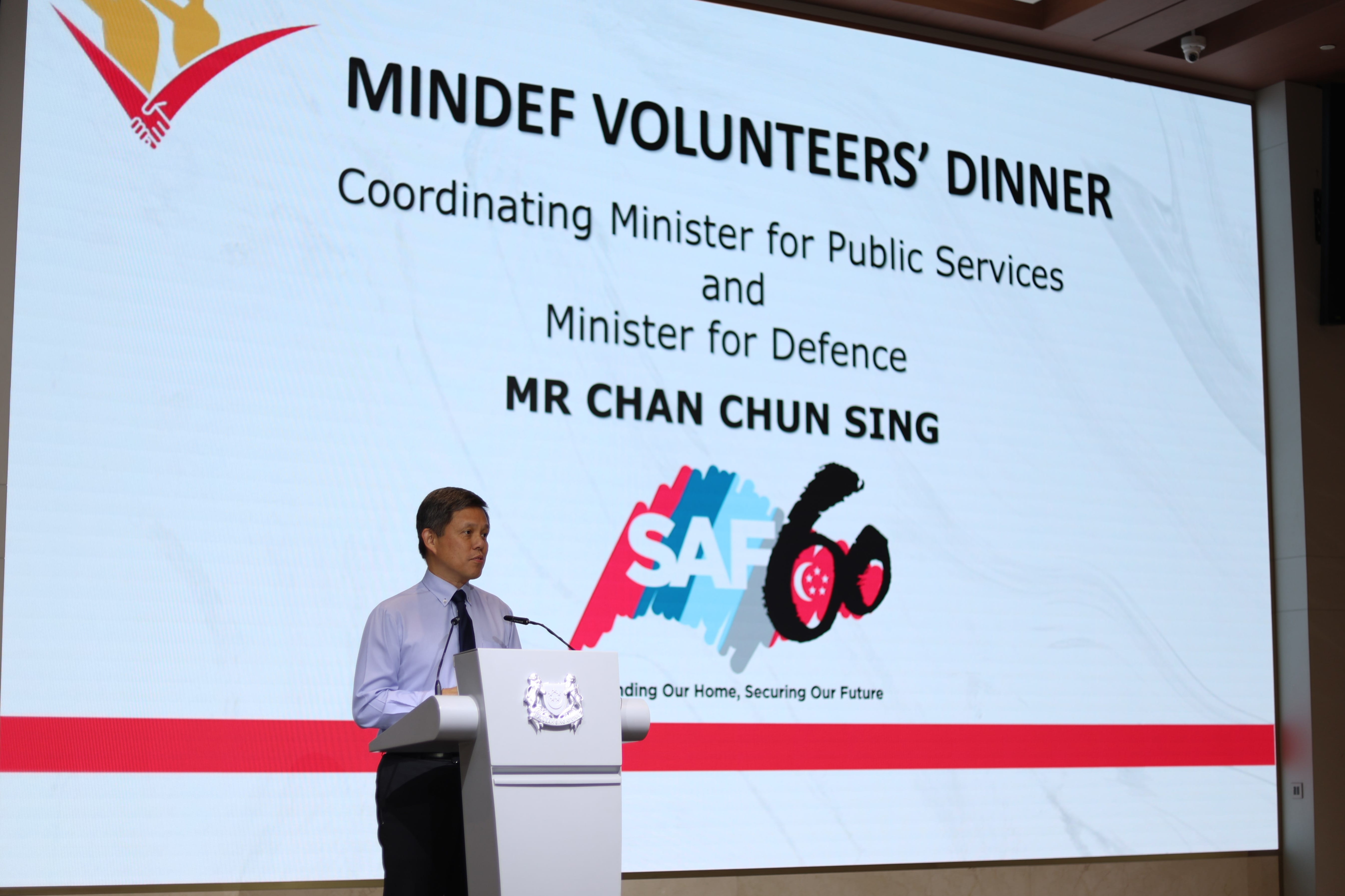 Mr. Chan Chun Sing at podium with MINDEF Volunteers' Dinner and SAF60 on the screen.