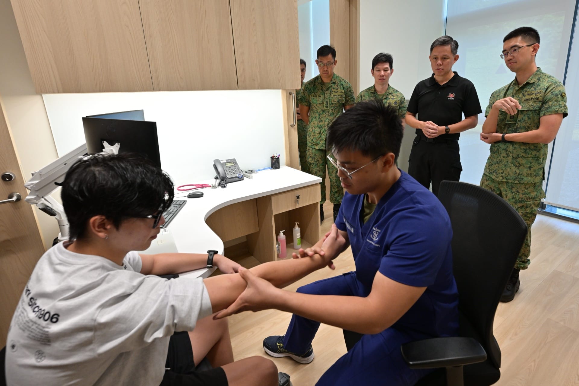 Mr Chan interacting with a pre-enlistee and medical officer during a consultation at the Medical Classification Centre (MCC).