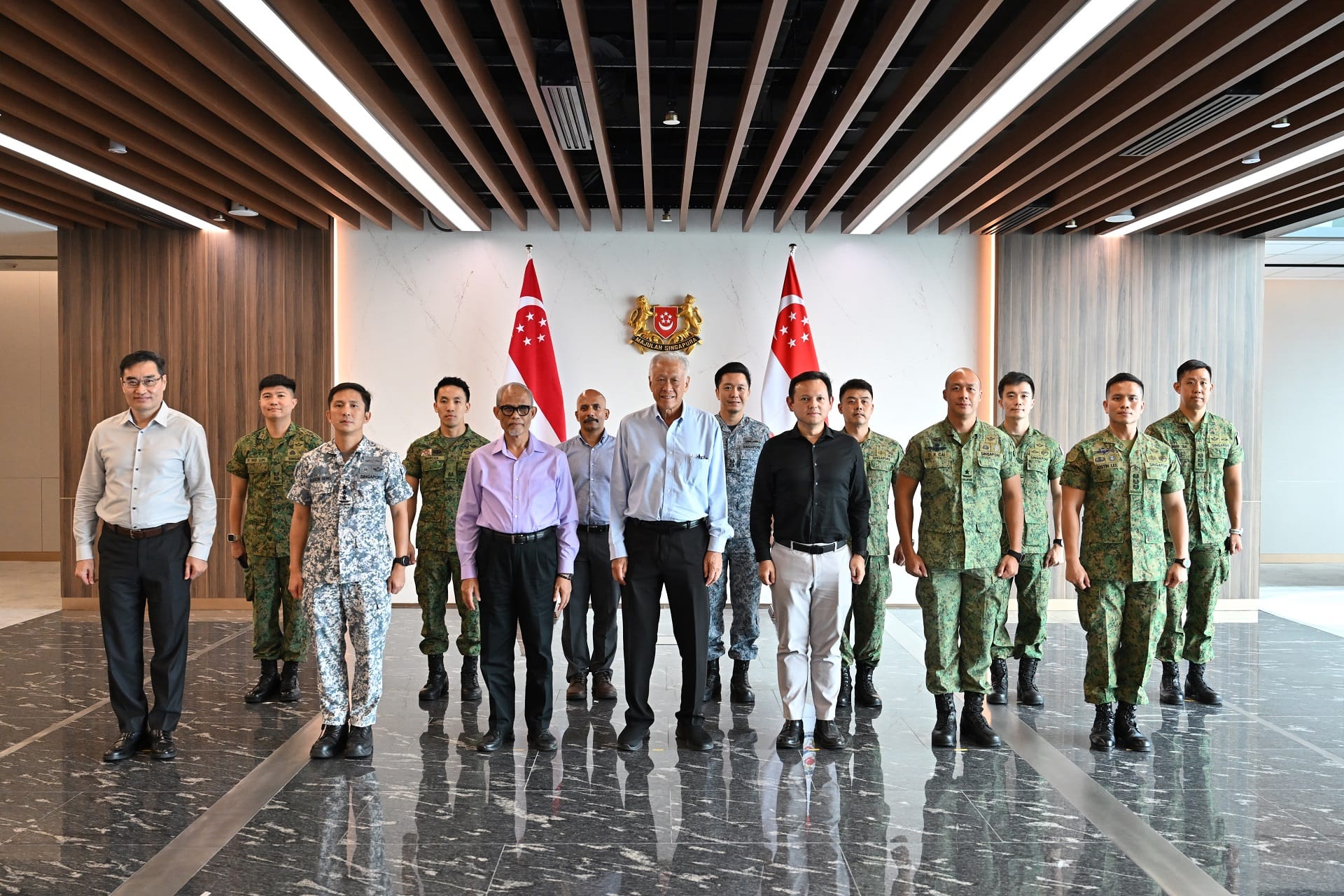 Dr Ng, Mr Masagos, Mr Zaqy, and senior SAF officers with personnel from the advance team and MOH.