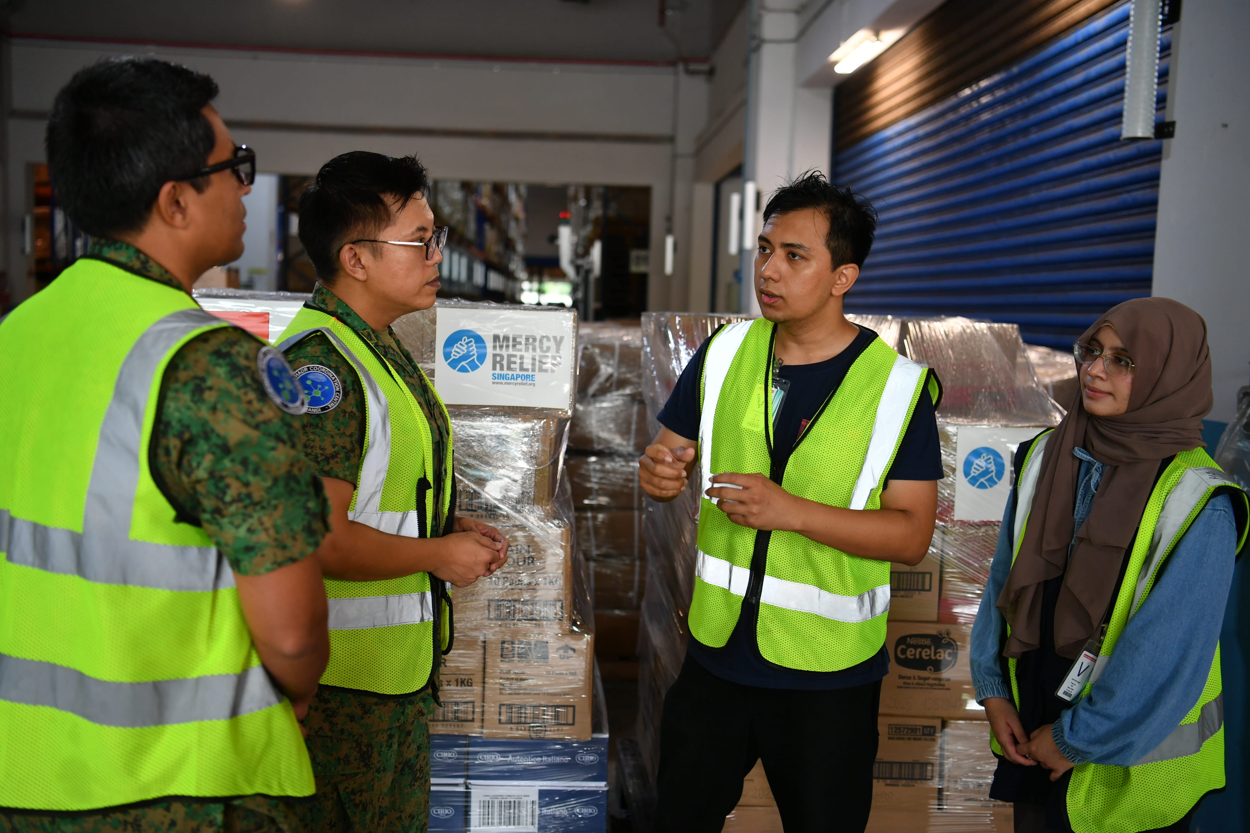 Changi RHCC personnel engaging Mercy Relief representatives during the handing over of humanitarian aid supplies. 