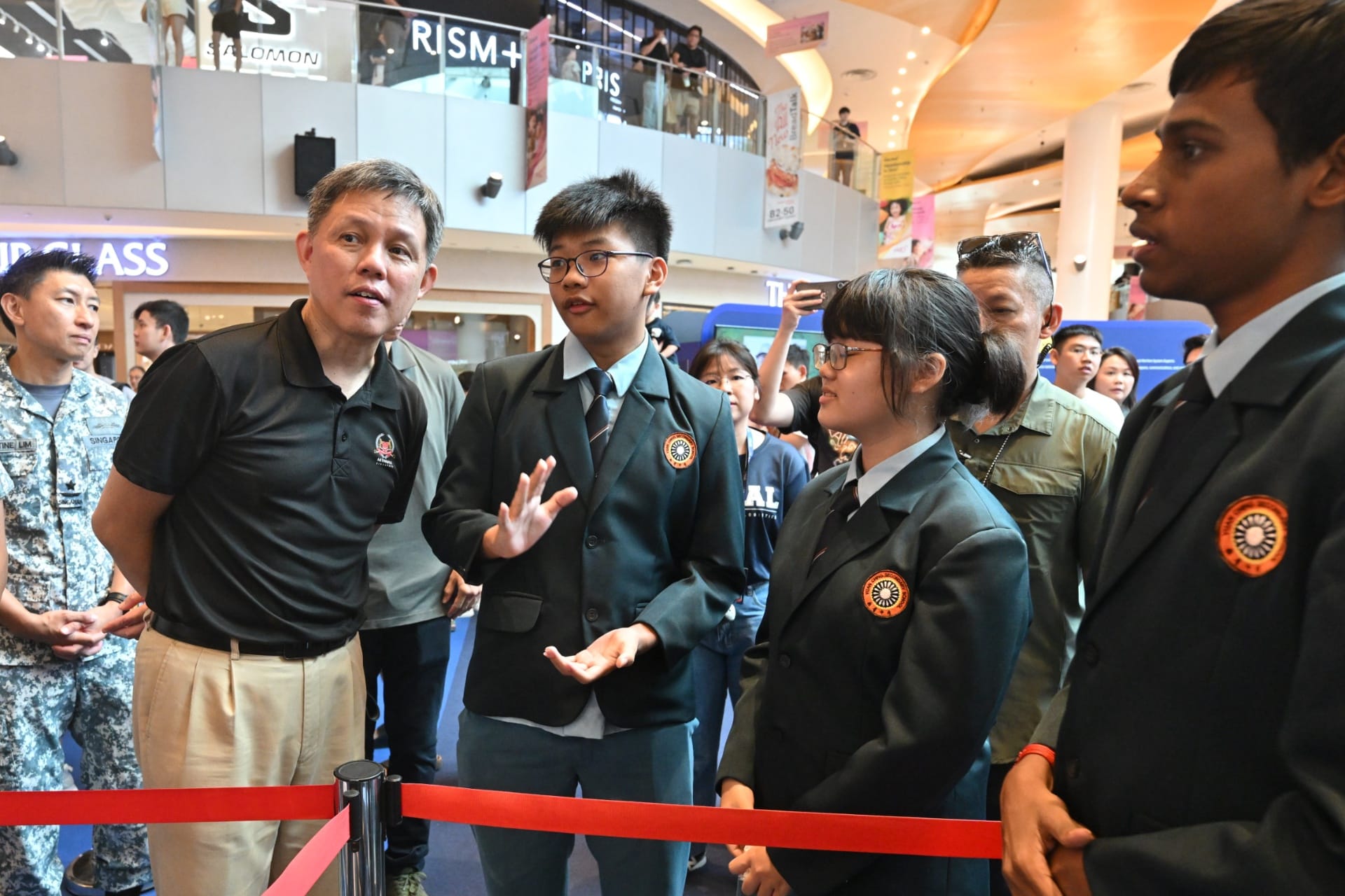 Ambassadors from Yuan Ching Secondary School giving Mr Chan a brief on the SeaPerch exhibit, a learning kit for designing remotely operated underwater vehicles.