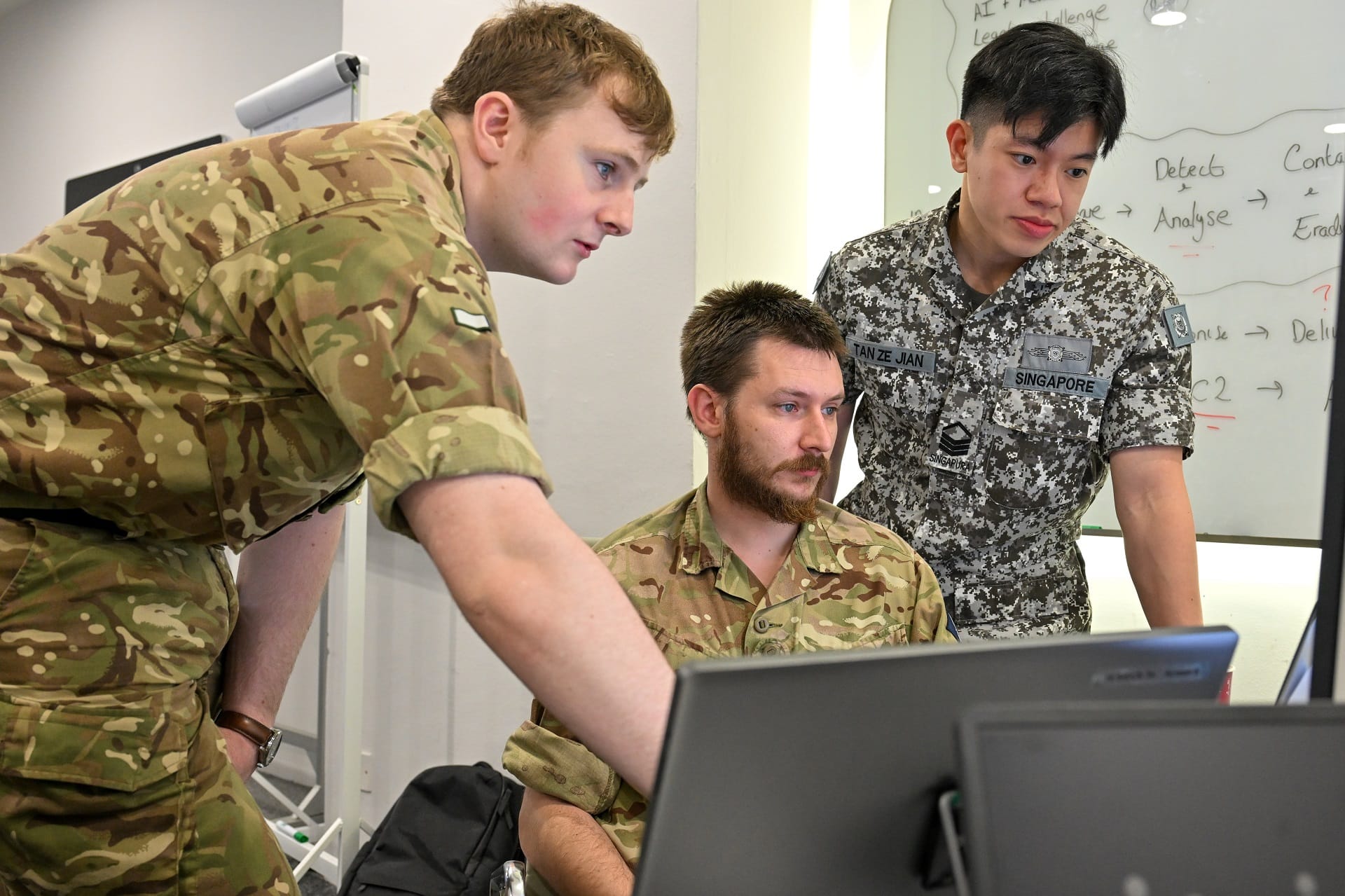 The DIS and British Army personnel collaborating to identify and mitigate a simulated cyber-attack.